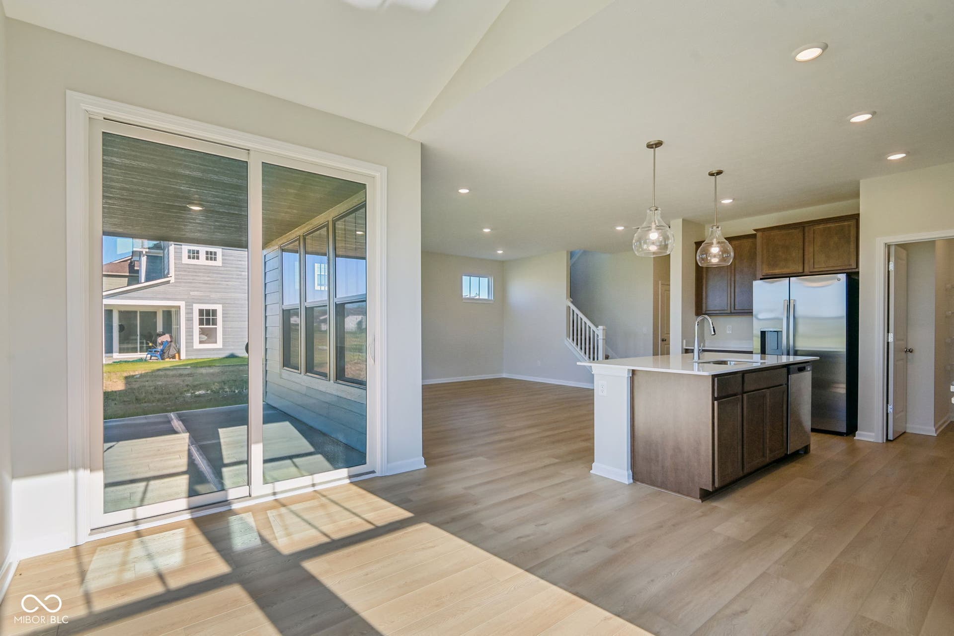 Open concept living area featuring wood-finish flooring and a white kitchen island with an integrated sink