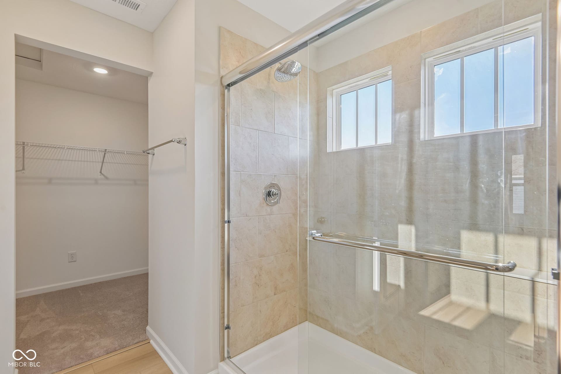 Glass-enclosed shower with tile surround and dual windows