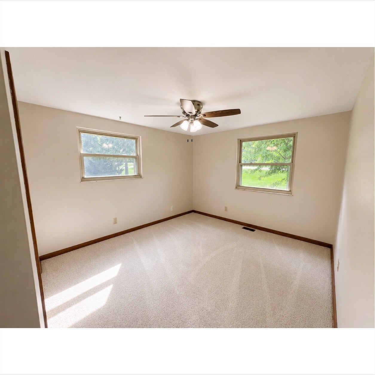 Bright room featuring light-colored carpet flooring and two windows