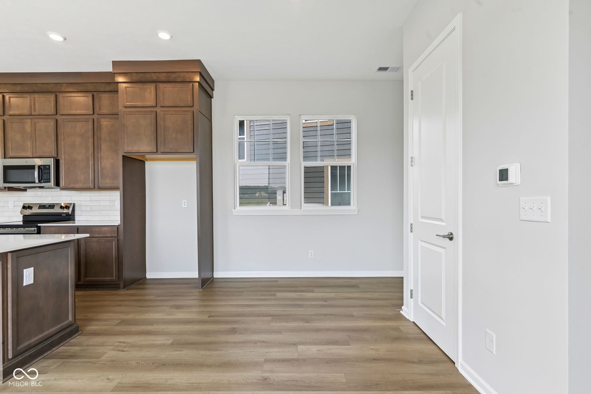 15762 Showdown Road, Noblesville, IN 46060 Open-concept kitchen and living area featuring wood-finish flooring, recessed lighting, white trim, and a window for natural light
