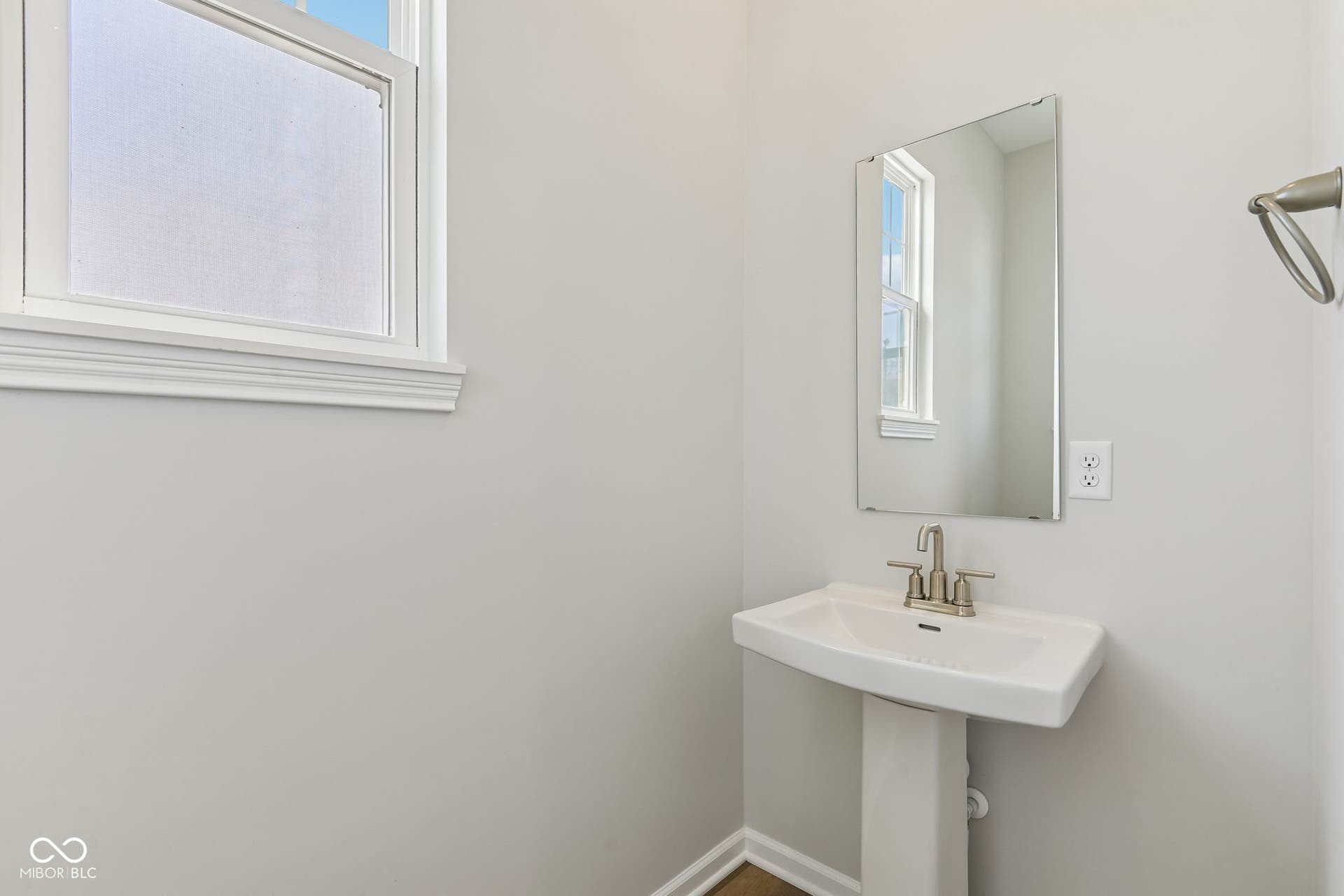 15762 Showdown Road, Noblesville, IN 46060 Pedestal sink with brushed nickel faucet, framed mirror, and natural light from a window