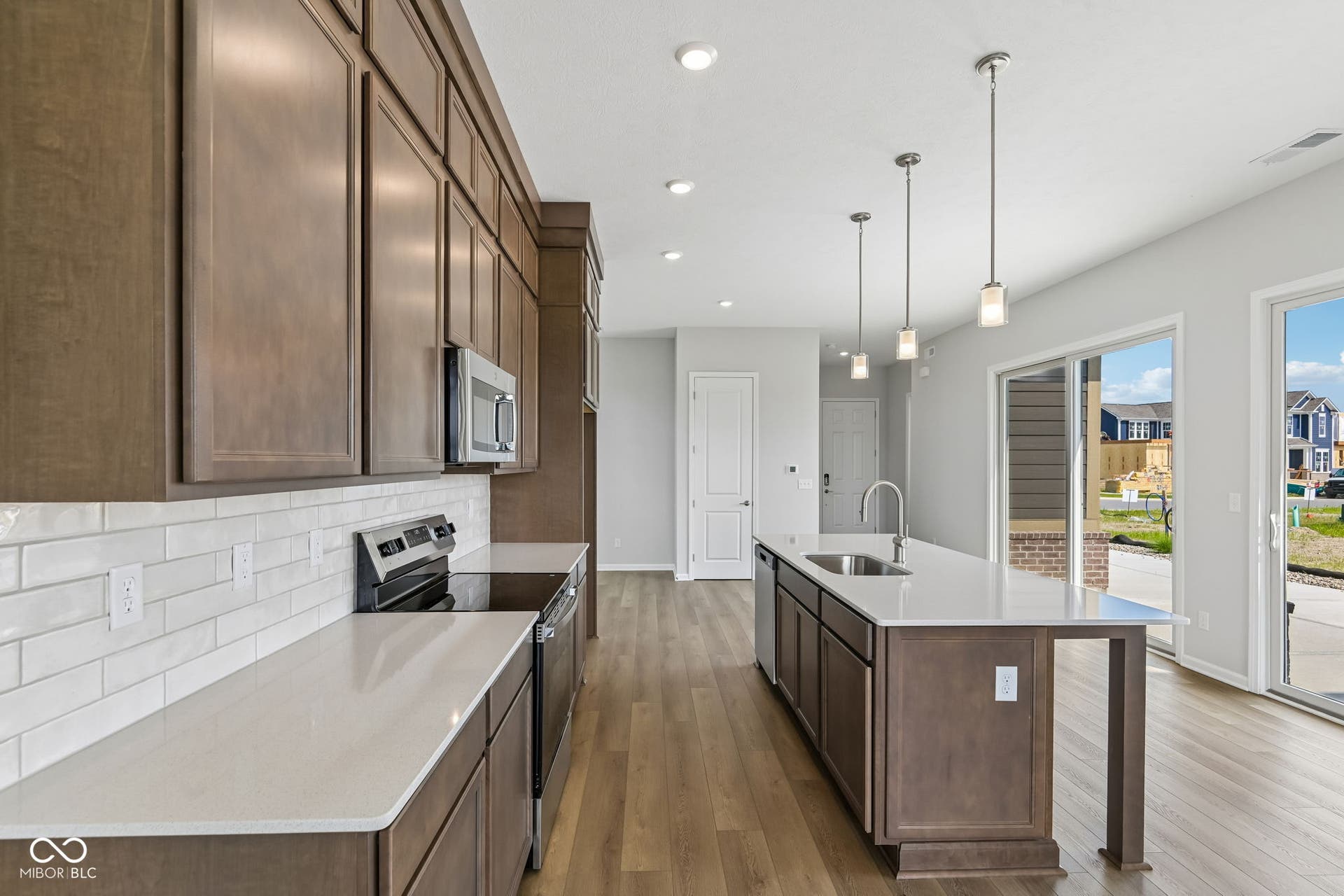 15762 Showdown Road, Noblesville, IN 46060 Modern kitchen featuring abundant cabinetry, stainless steel appliances, a subway tile backsplash, and light-toned countertops