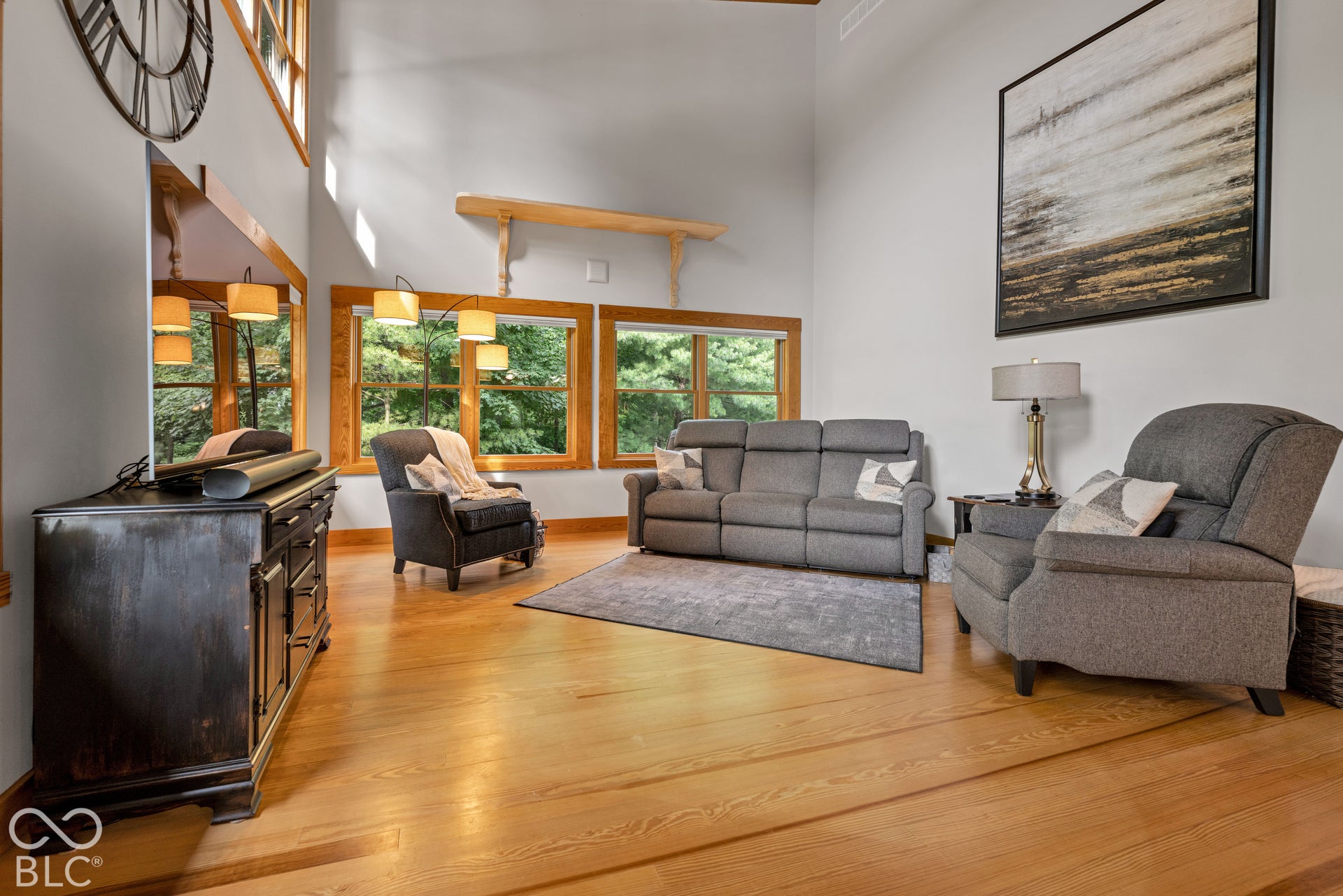Vaulted ceilings, wood-finish flooring, and multiple windows with wood trim