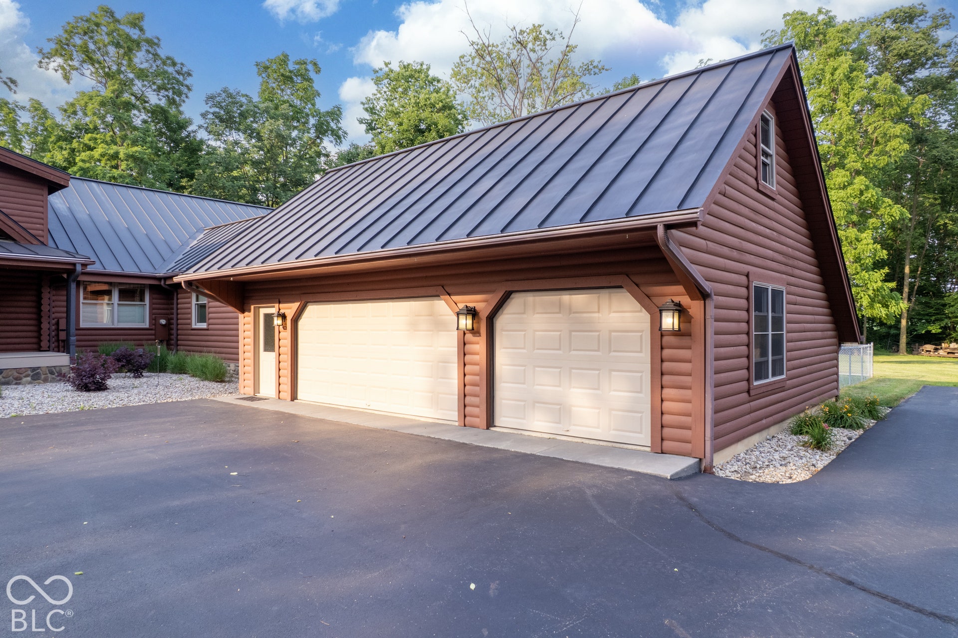 Attached two-car garage with a metal roof and wood-look siding