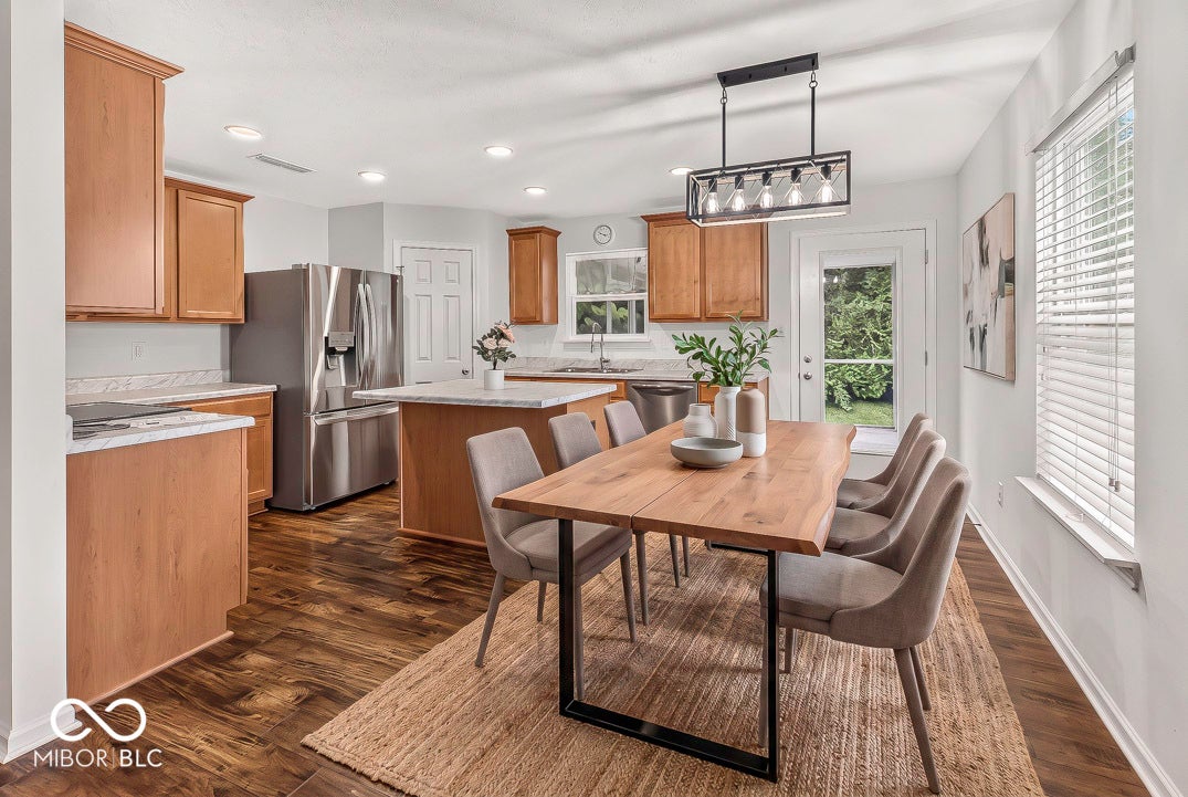 Virtually Altered - Wood-finish flooring throughout, complemented by a kitchen island with stone countertops