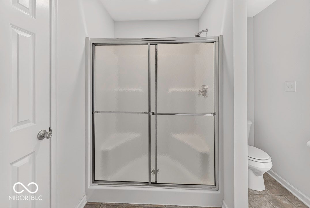 Shower enclosure with sliding glass doors and integrated seating