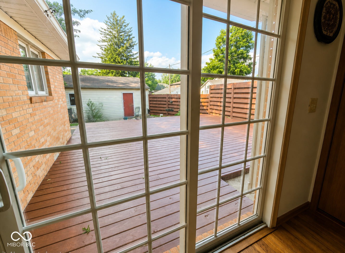Expansive outdoor deck featuring a rich wood finish and privacy fencing