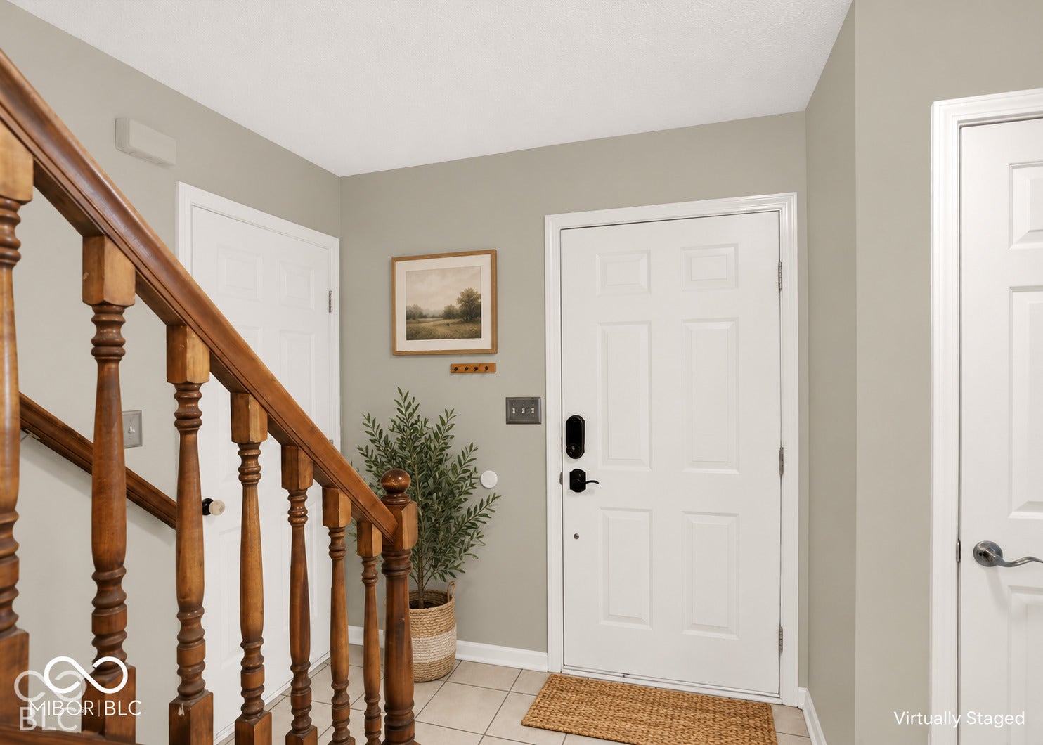Tiled flooring, wood balustrade, paneled doors, and light gray wall paint