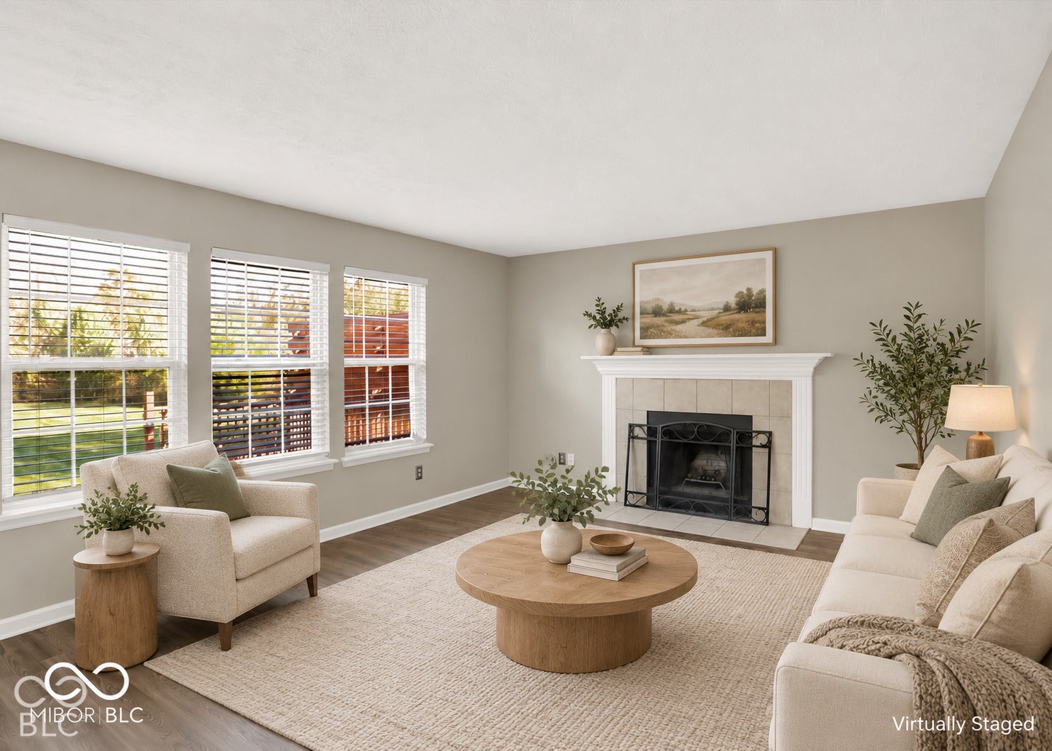Living area featuring three large windows, wood-finish flooring, a fireplace with a tiled surround, and a mantel