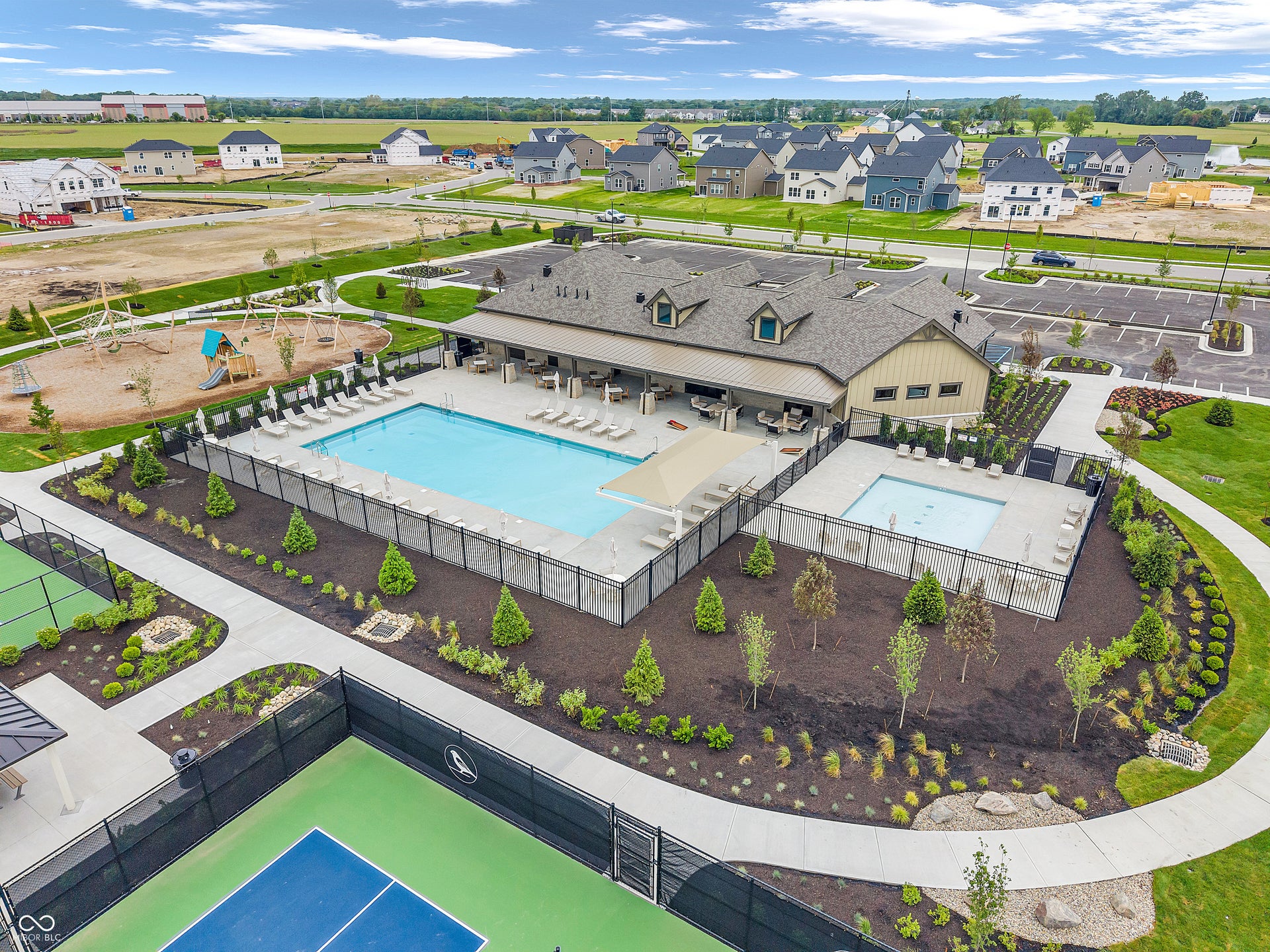 Community amenities featuring two tennis/pickleball courts, an outdoor swimming pool, a separate spa, a playground, and a clubhouse with covered outdoor seating