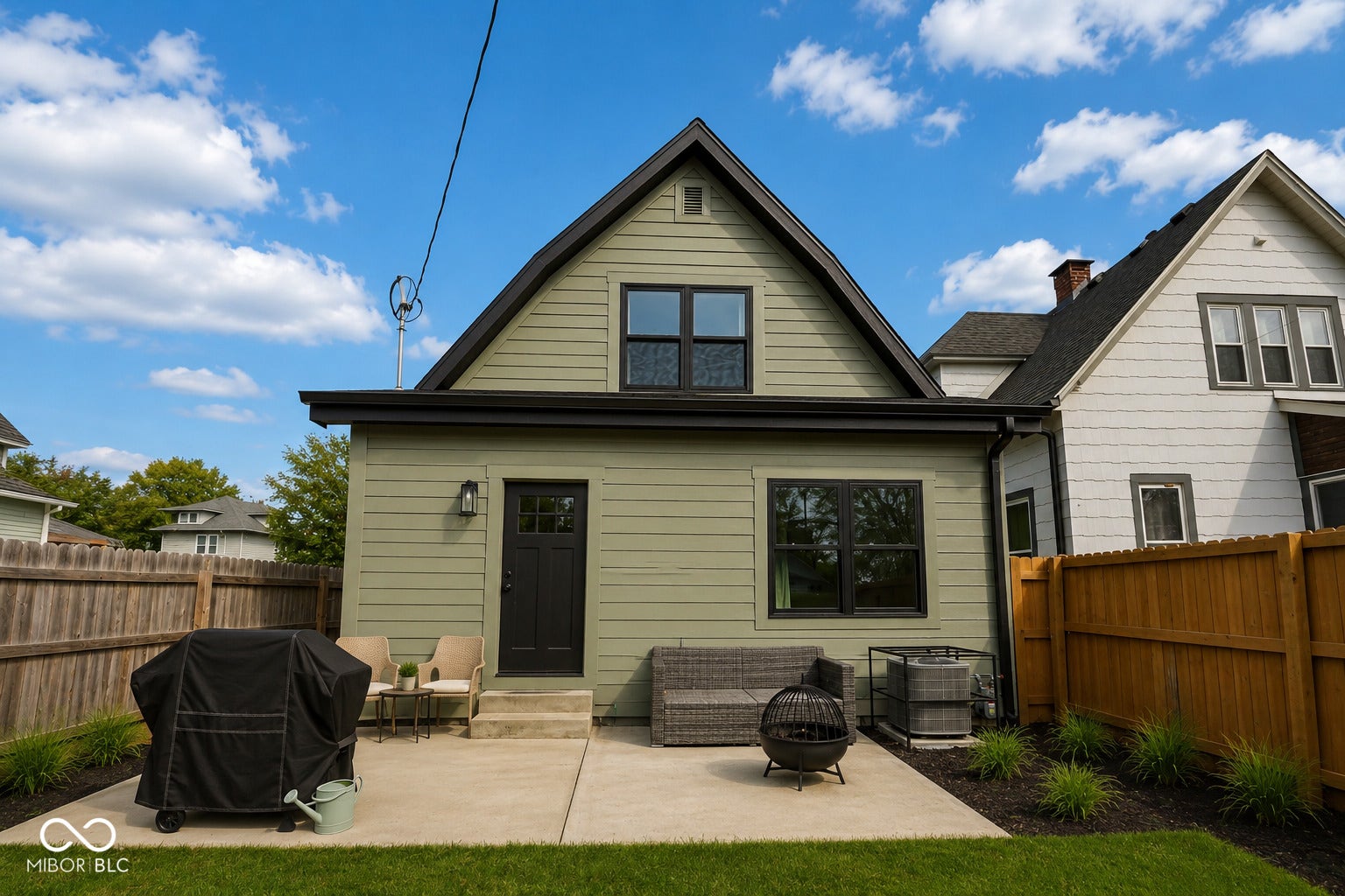 Virtually Altered - Rear exterior featuring light green siding and black trim accents