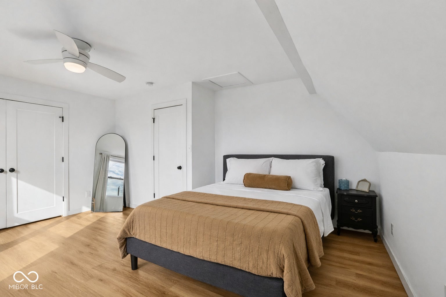 Bedroom 2: featuring wood-finish flooring, white walls, and a sloped ceiling