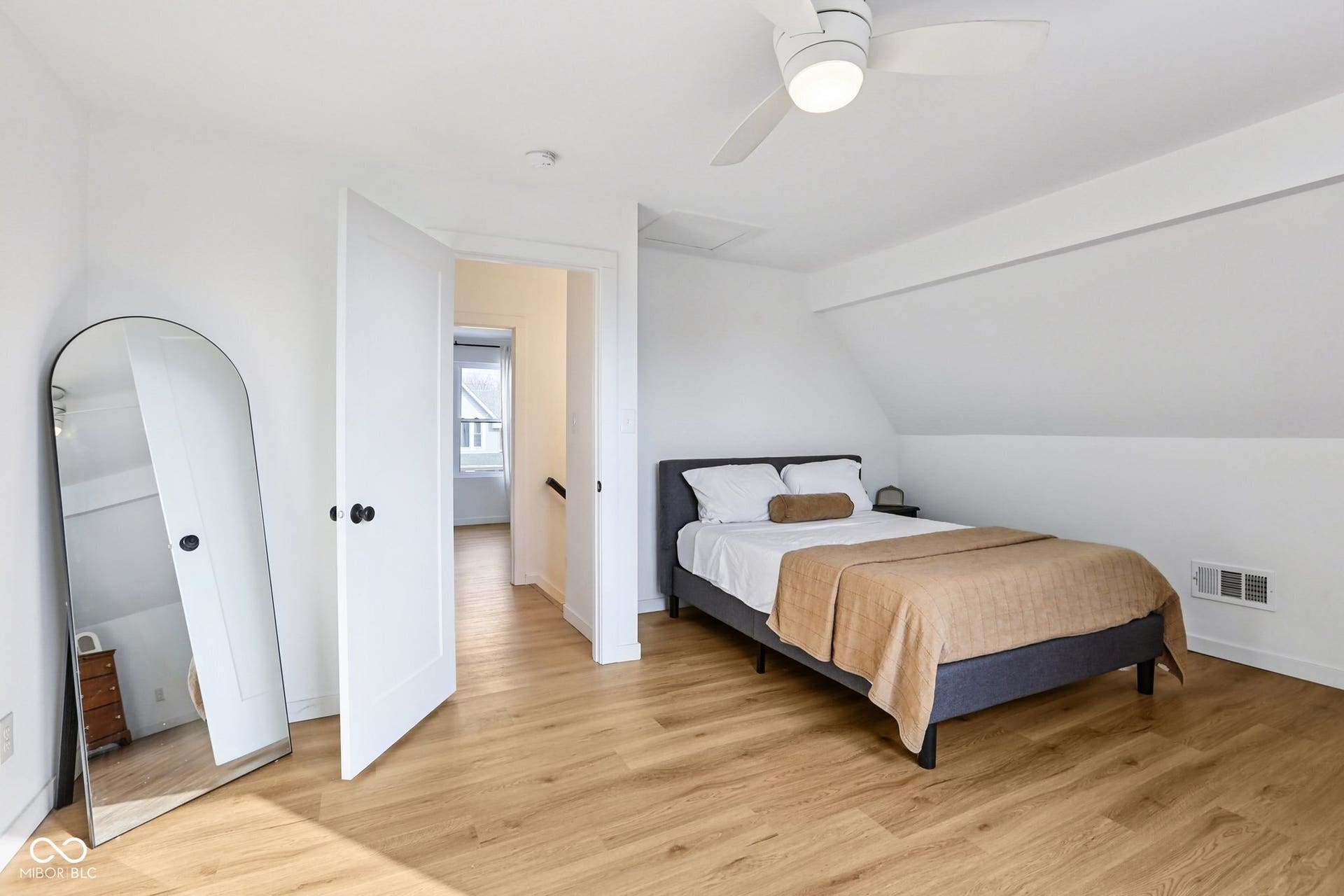 Bedroom 2: featuring light wood-finish flooring, a contemporary ceiling fan, white trim, and a sloped ceiling detail