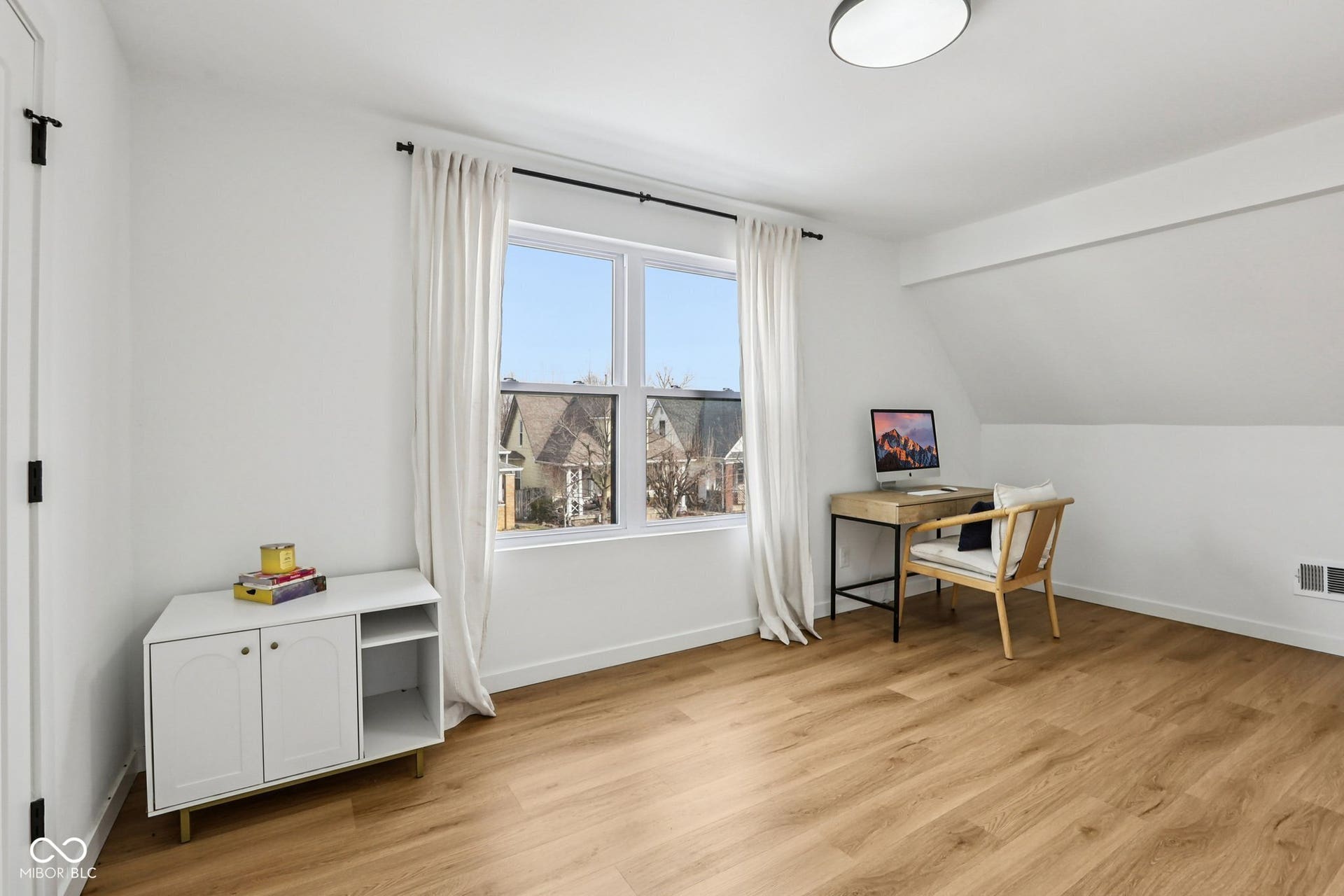 bedroom 3: Bright room with wood-finish flooring and white walls