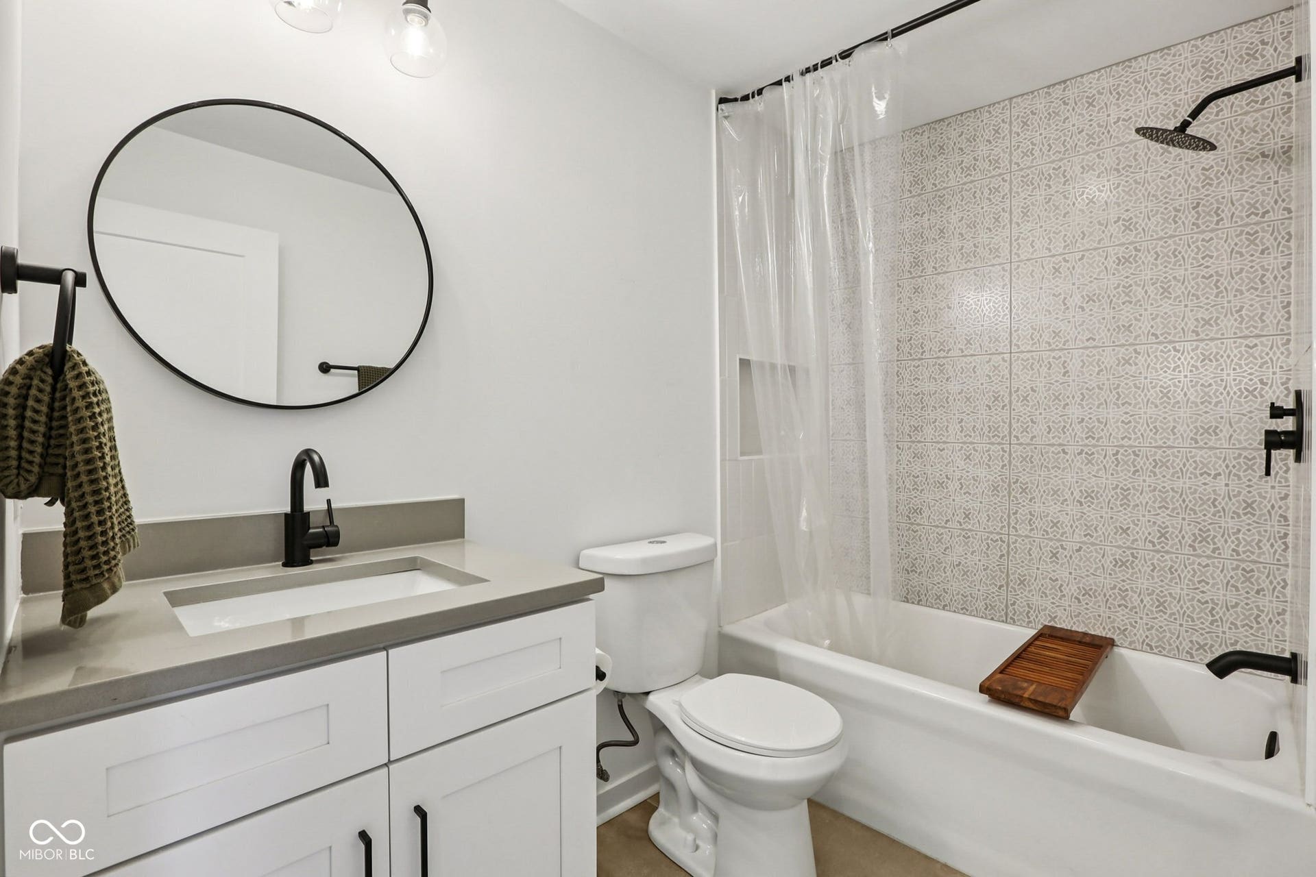 Bathroom featuring a white vanity with slab countertop, undermount sink, and matte black faucet