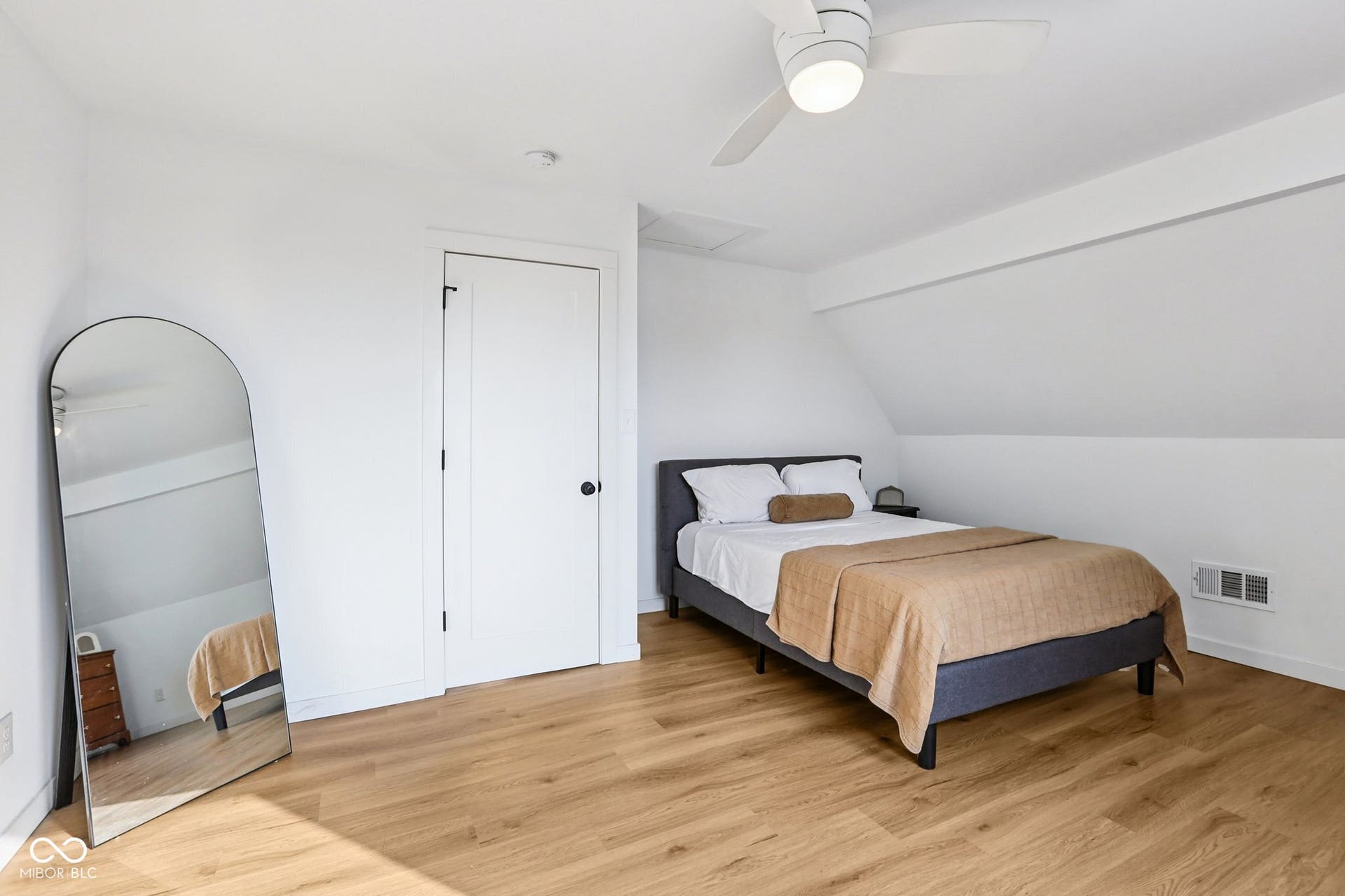 Bedroom 2: Bright bedroom featuring wood-finish flooring, a white ceiling fan with integrated lighting, and a white interior door with black hardware
