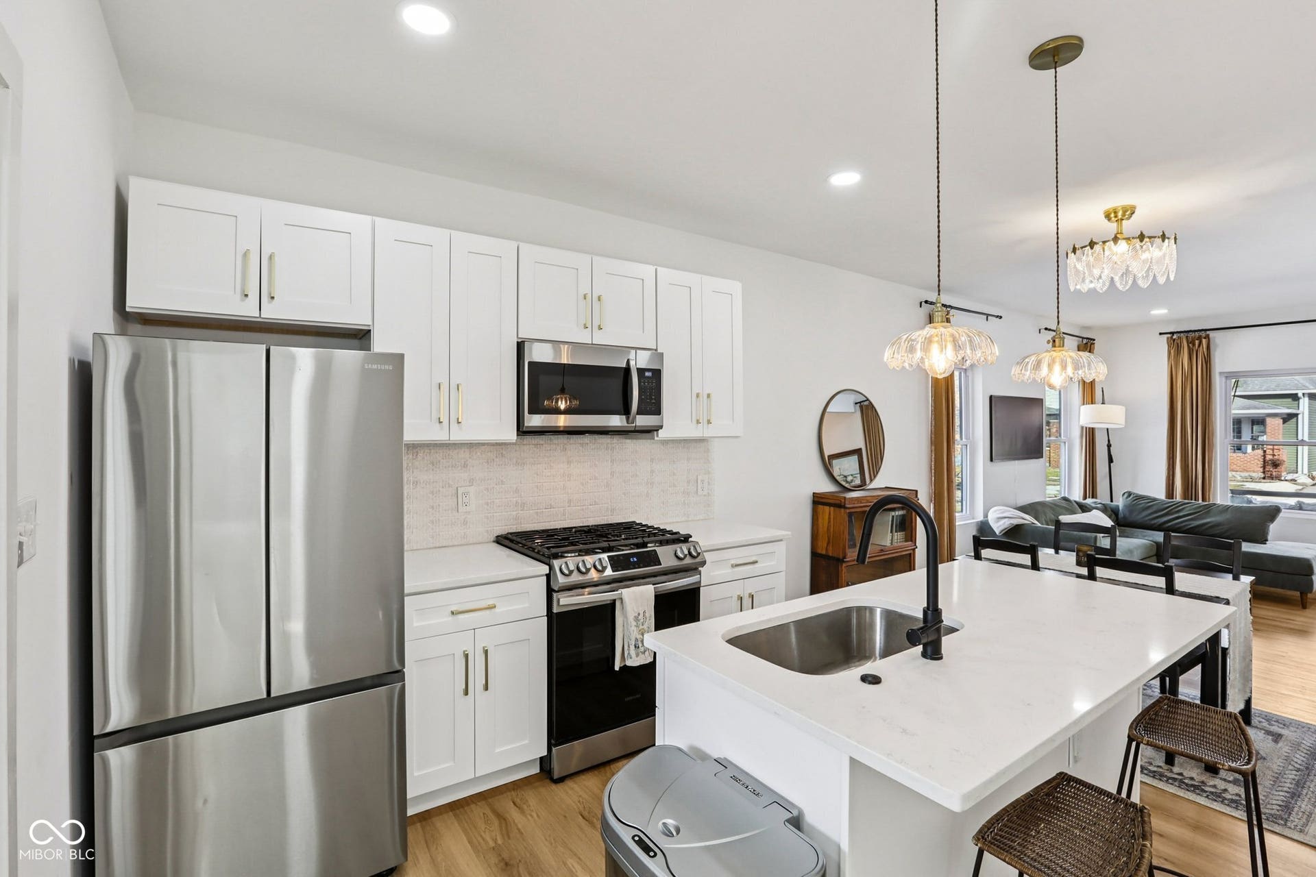 Kitchen with white shaker cabinetry, stainless steel appliances, and a tiled backsplash