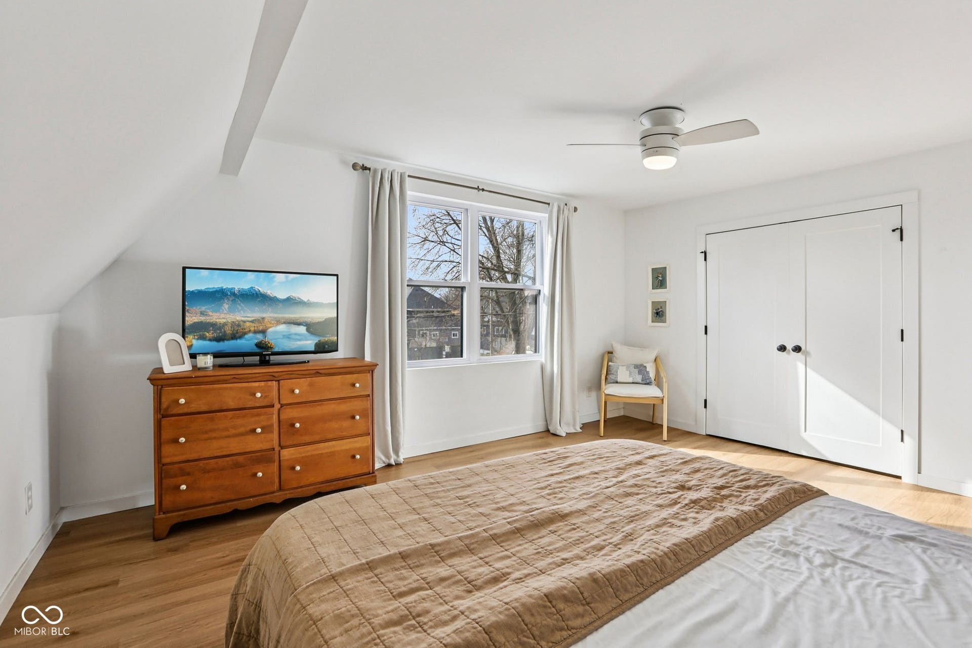 Bedroom 2: Bright room featuring white walls, wood-finish flooring, and a ceiling fan with integrated lighting