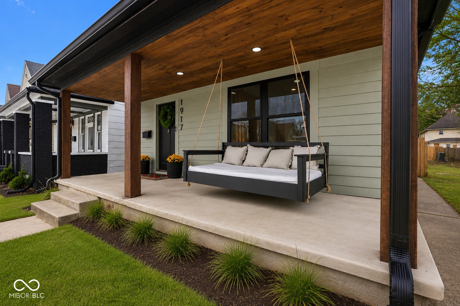 Virtually Altered - Inviting front porch featuring a wood-finish ceiling, recessed lighting, and a concrete foundation