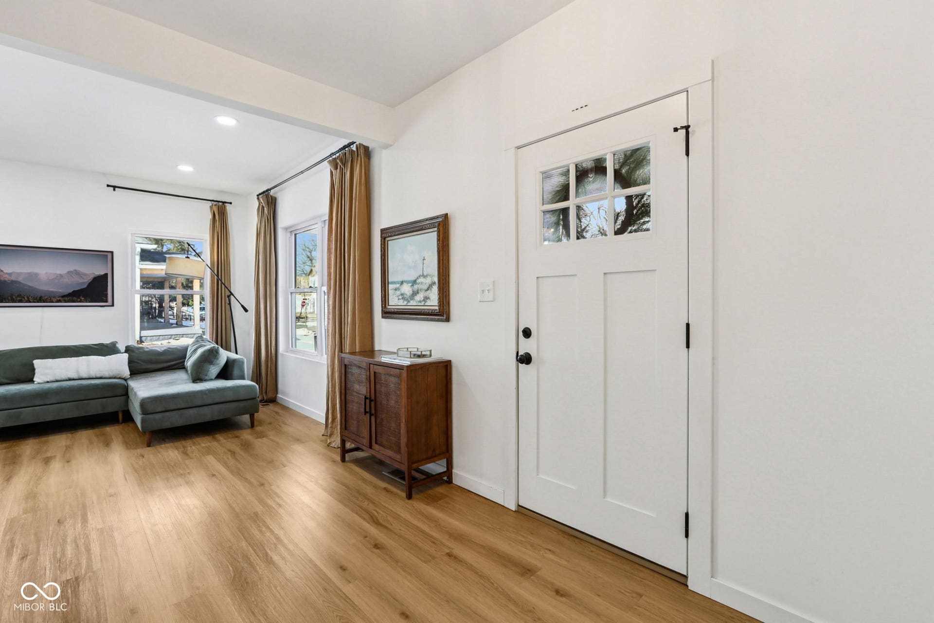 Bright entry area featuring a white craftsman-style door with upper lites