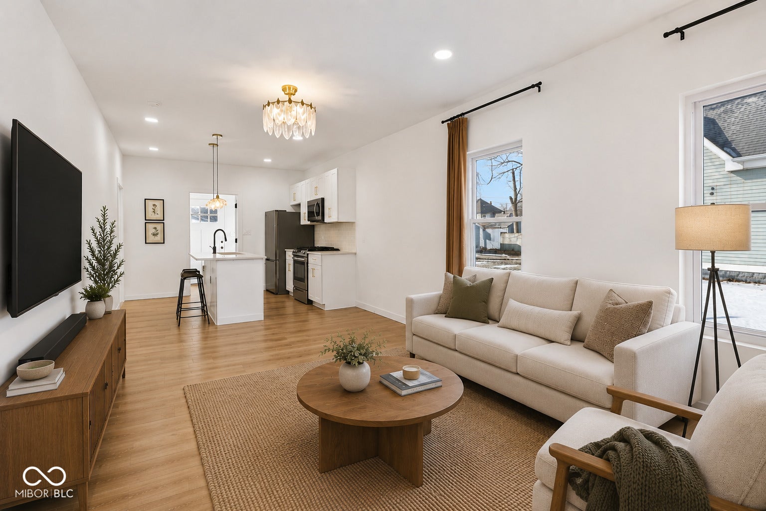 Virtually Altered - Open-concept living space featuring wood-finish flooring, recessed lighting, and a decorative chandelier