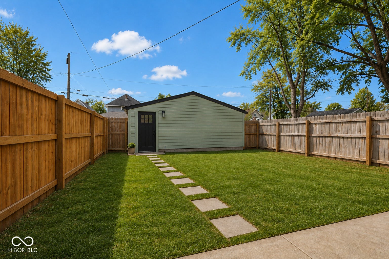 Virtually Altered - Expansive backyard featuring a lush lawn, privacy fencing, and concrete patio