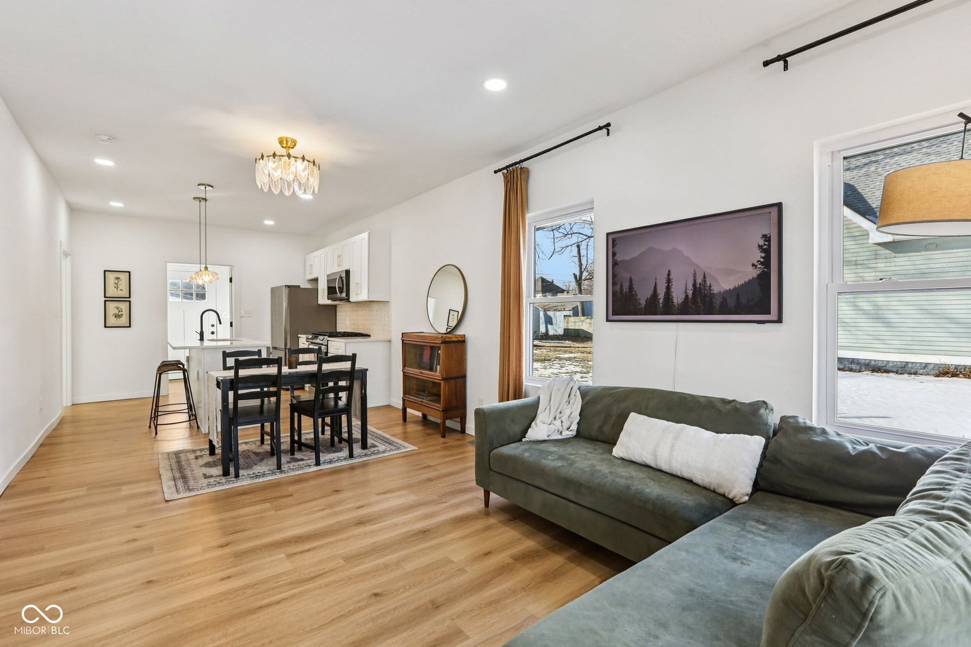 Open-concept living area featuring light wood-finish flooring, recessed lighting, and white walls