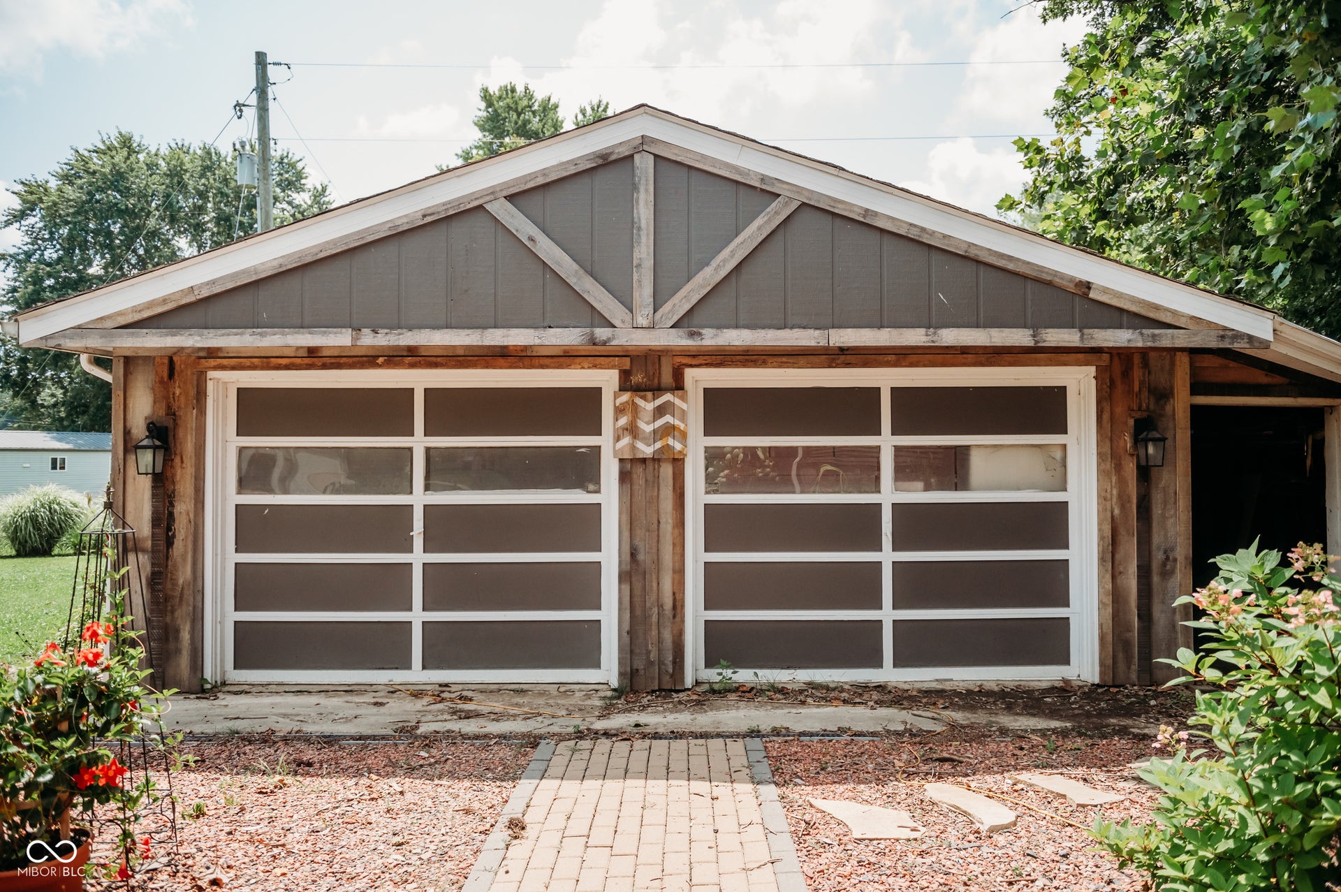Two-car garage featuring modern frosted-panel doors and an adjacent covered entry