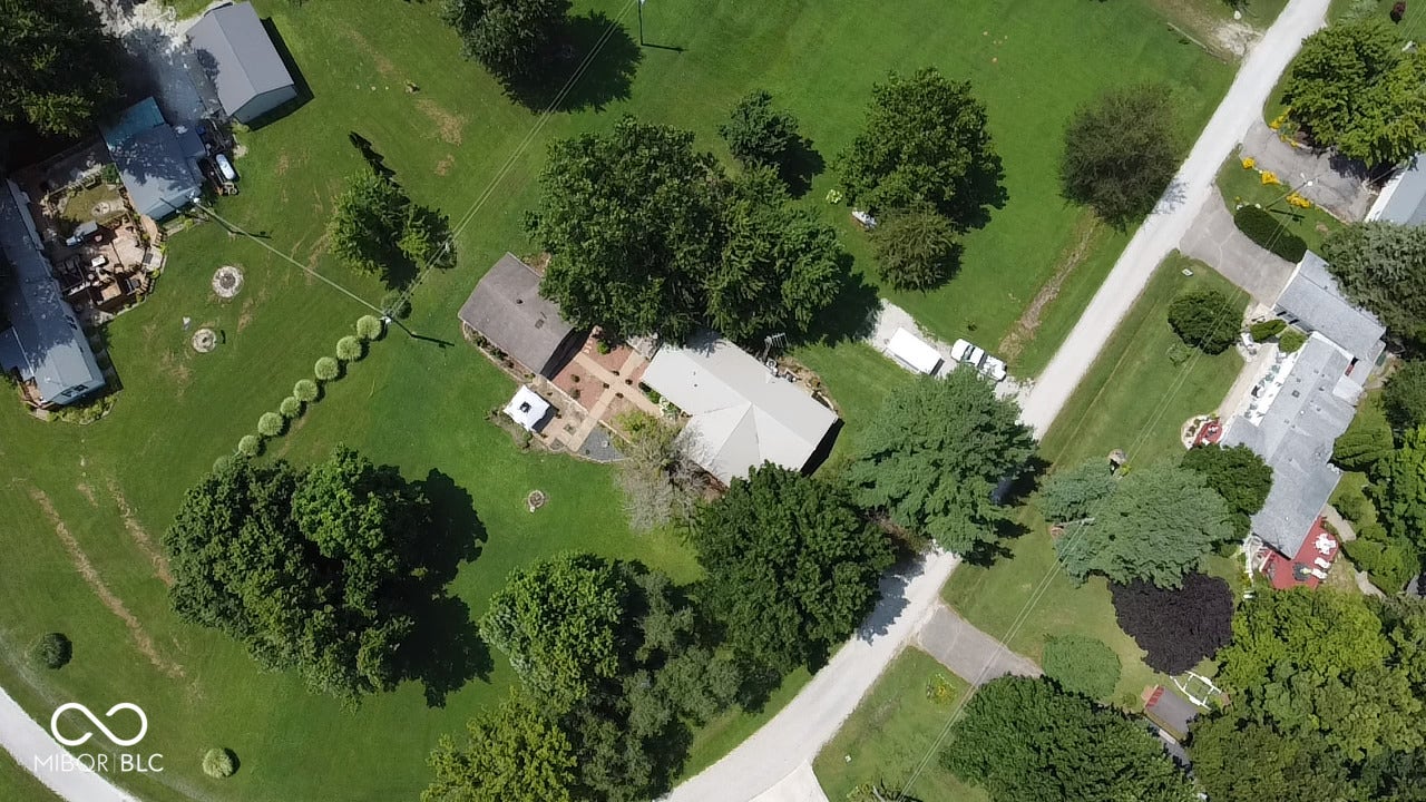 Expansive residential property featuring a gray-roofed single-story residence with an attached brick patio