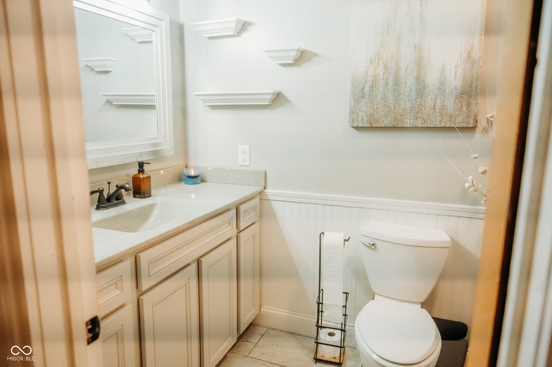 Bathroom featuring a vanity with an integrated sink, light-toned countertop, and white cabinet storage