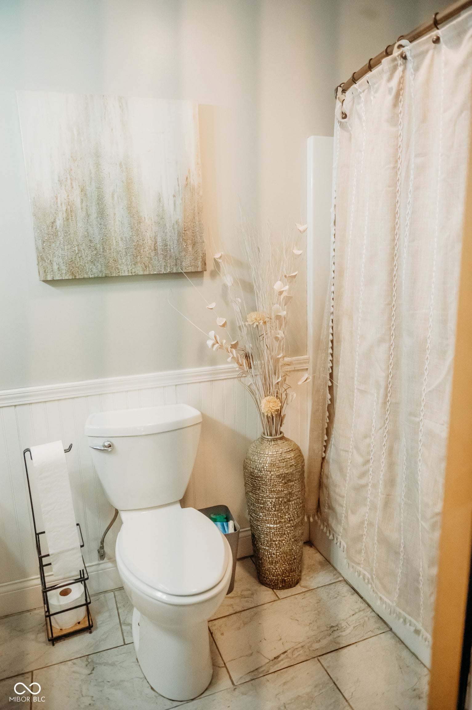 Bathroom featuring wainscoting, a standard toilet, and tile flooring