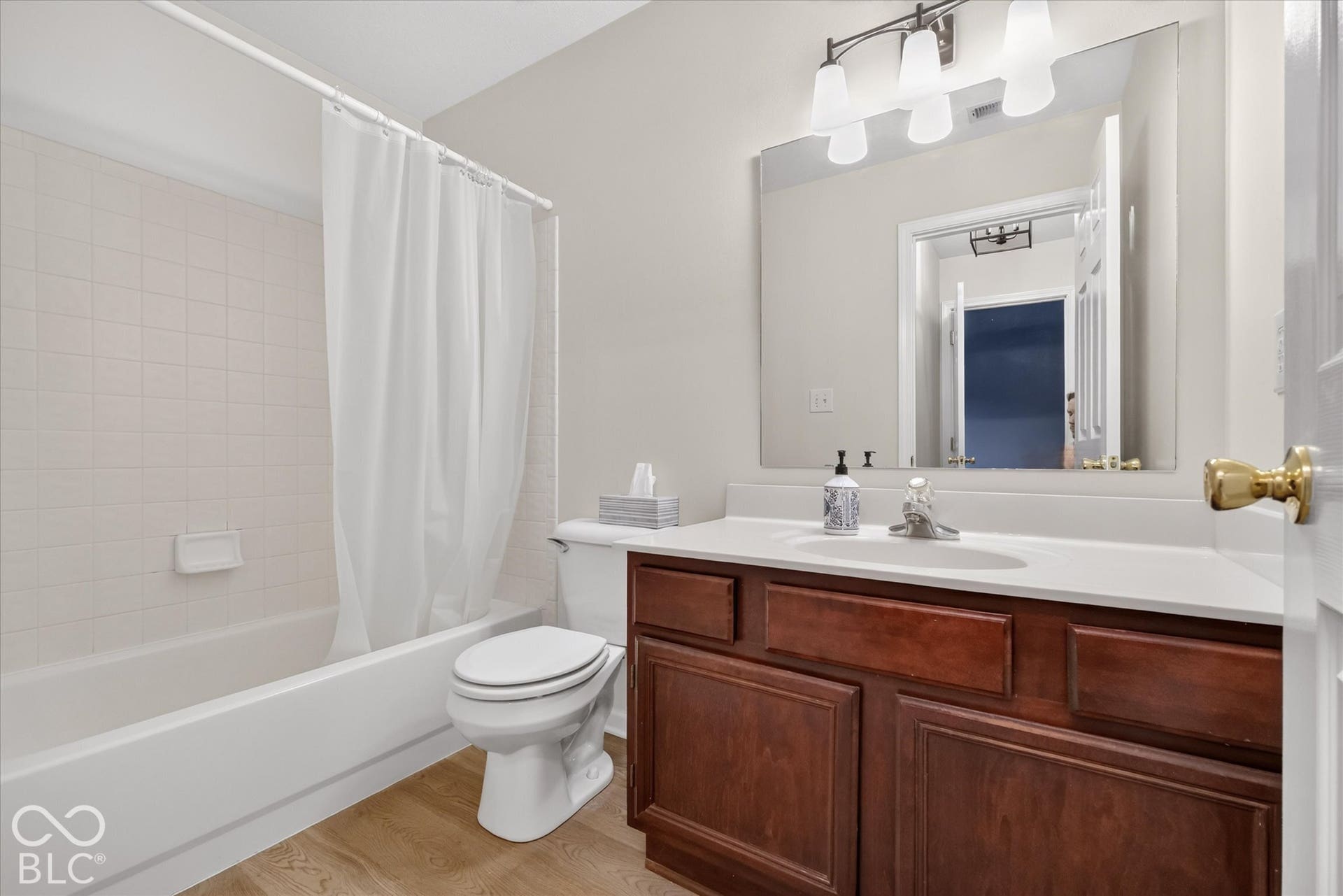 Upstairs bath with fresh paint, new flooring and light fixture.
