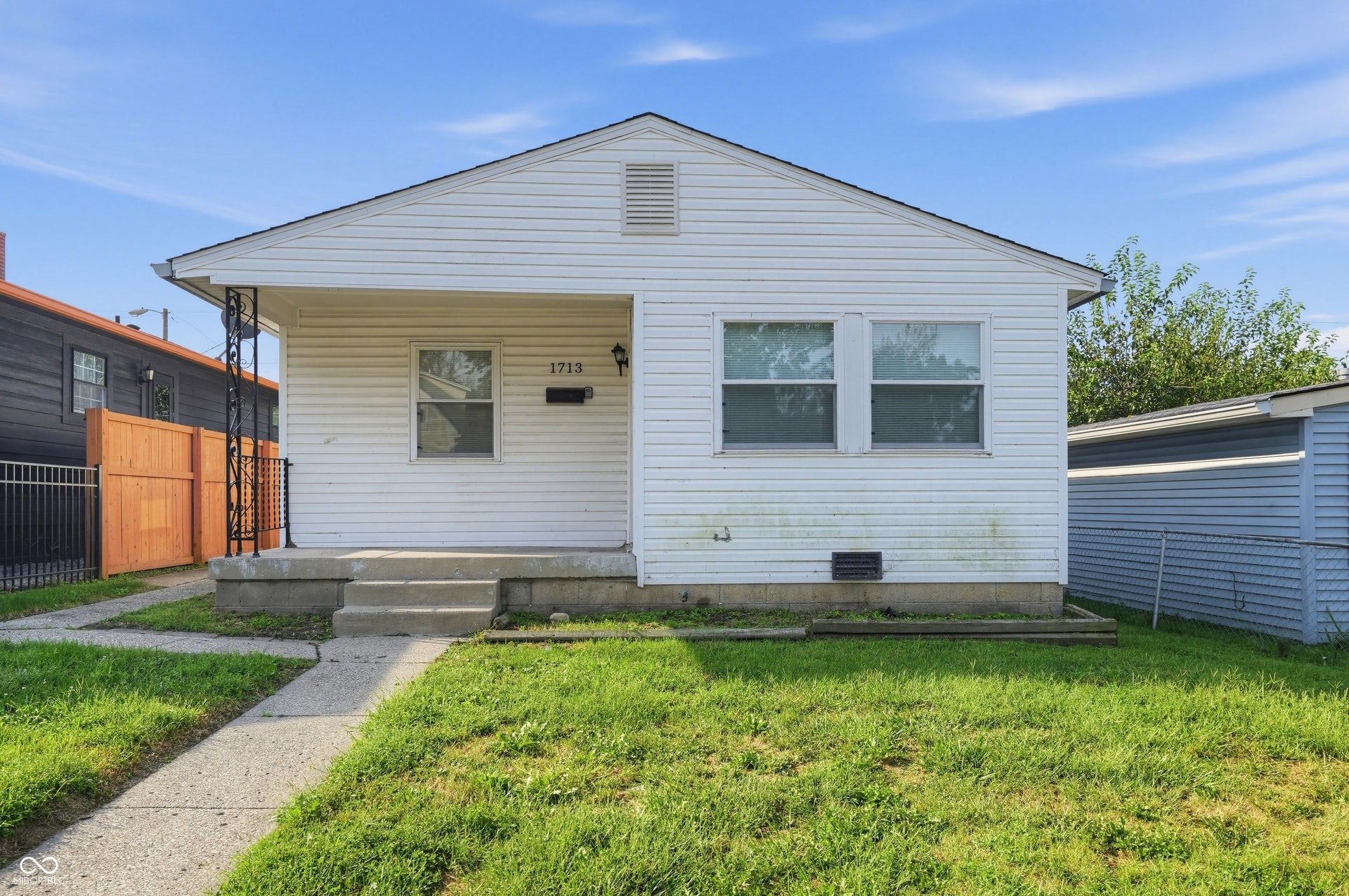White siding exterior with a covered porch and concrete steps