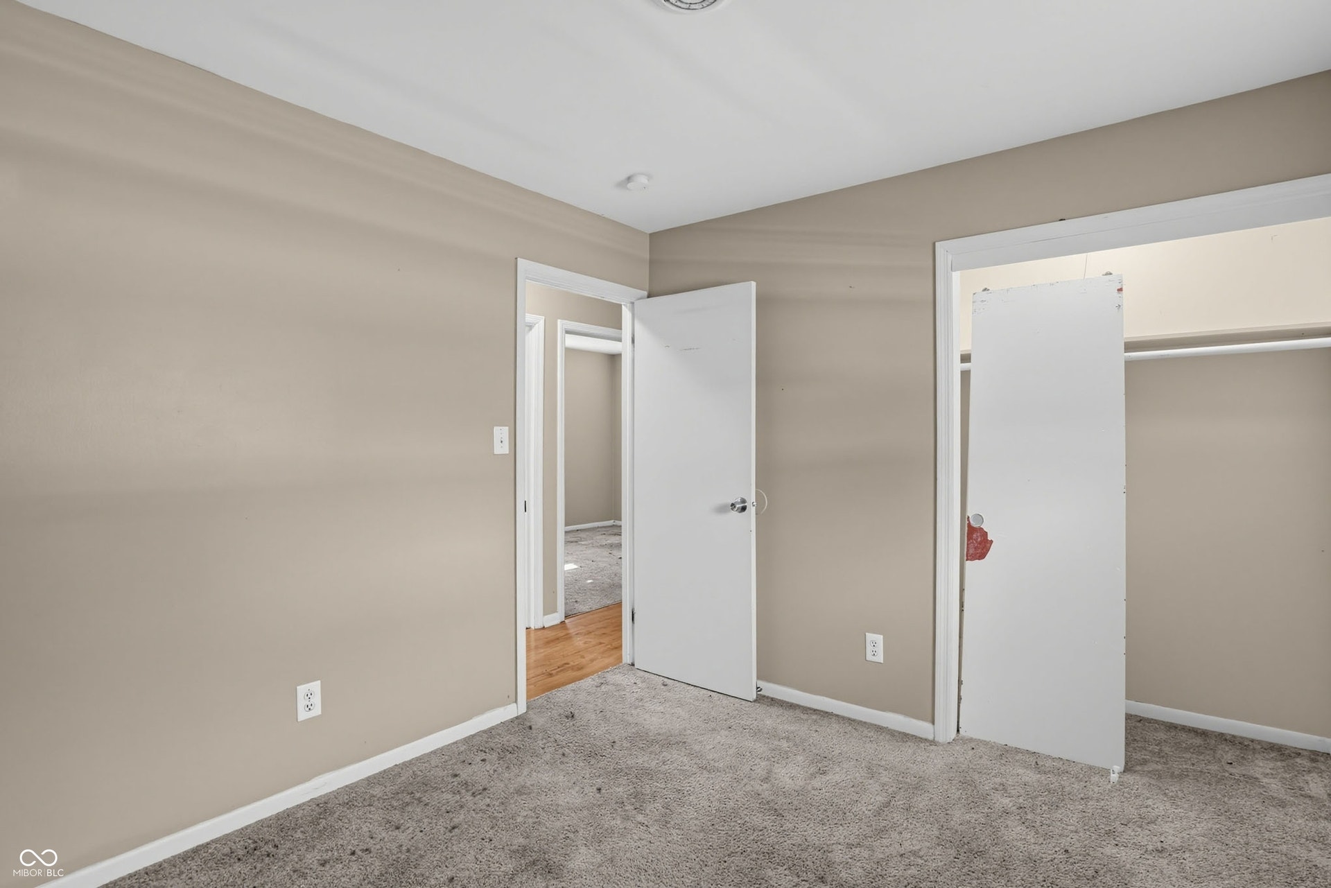 Carpeted flooring, neutral wall color, white trim, recessed lighting, and a built-in closet with hanging rod