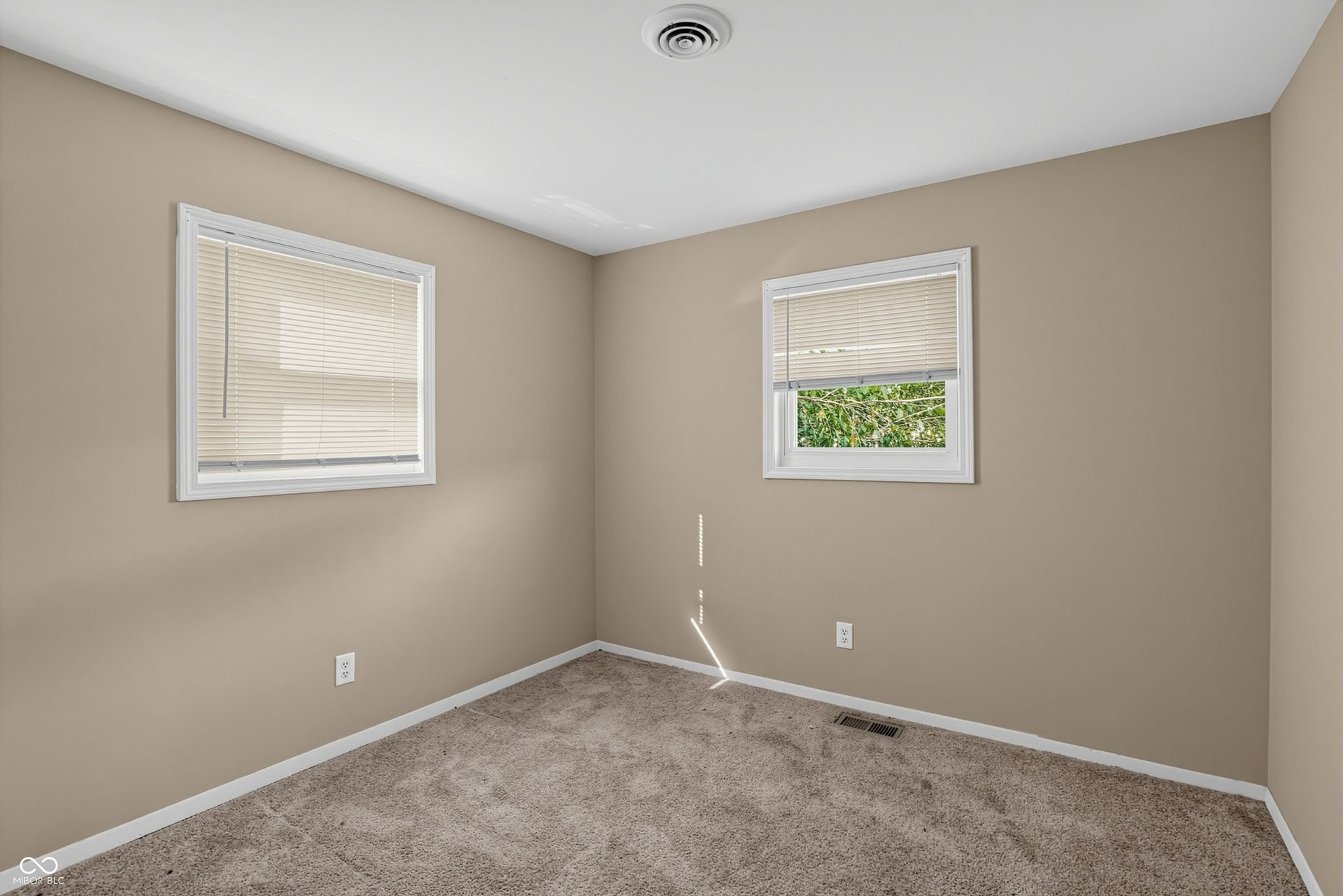 Neutral-toned walls complement plush carpeting