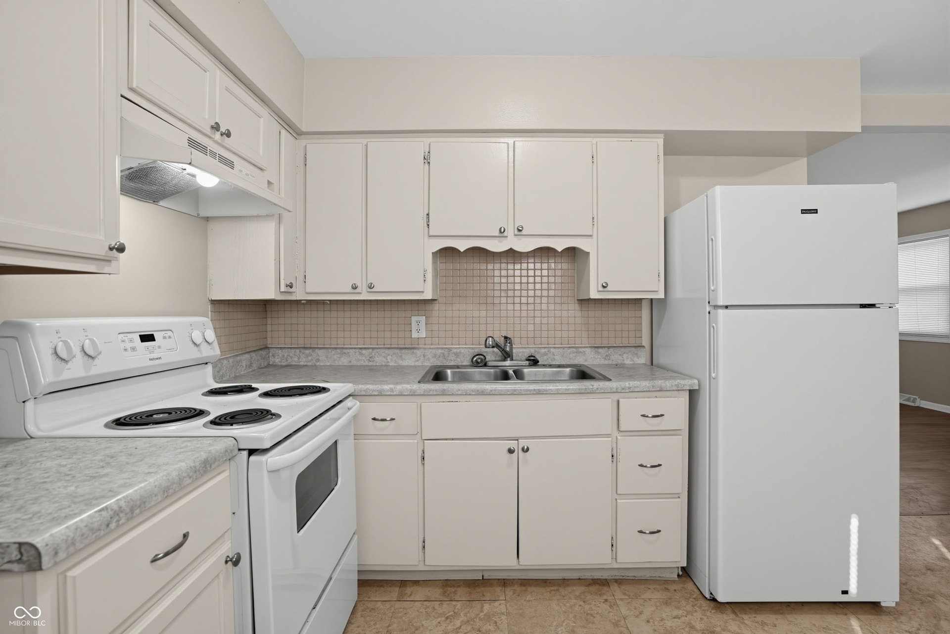 Kitchen featuring white cabinetry, a double basin sink, white range, white refrigerator, and a tiled backsplash