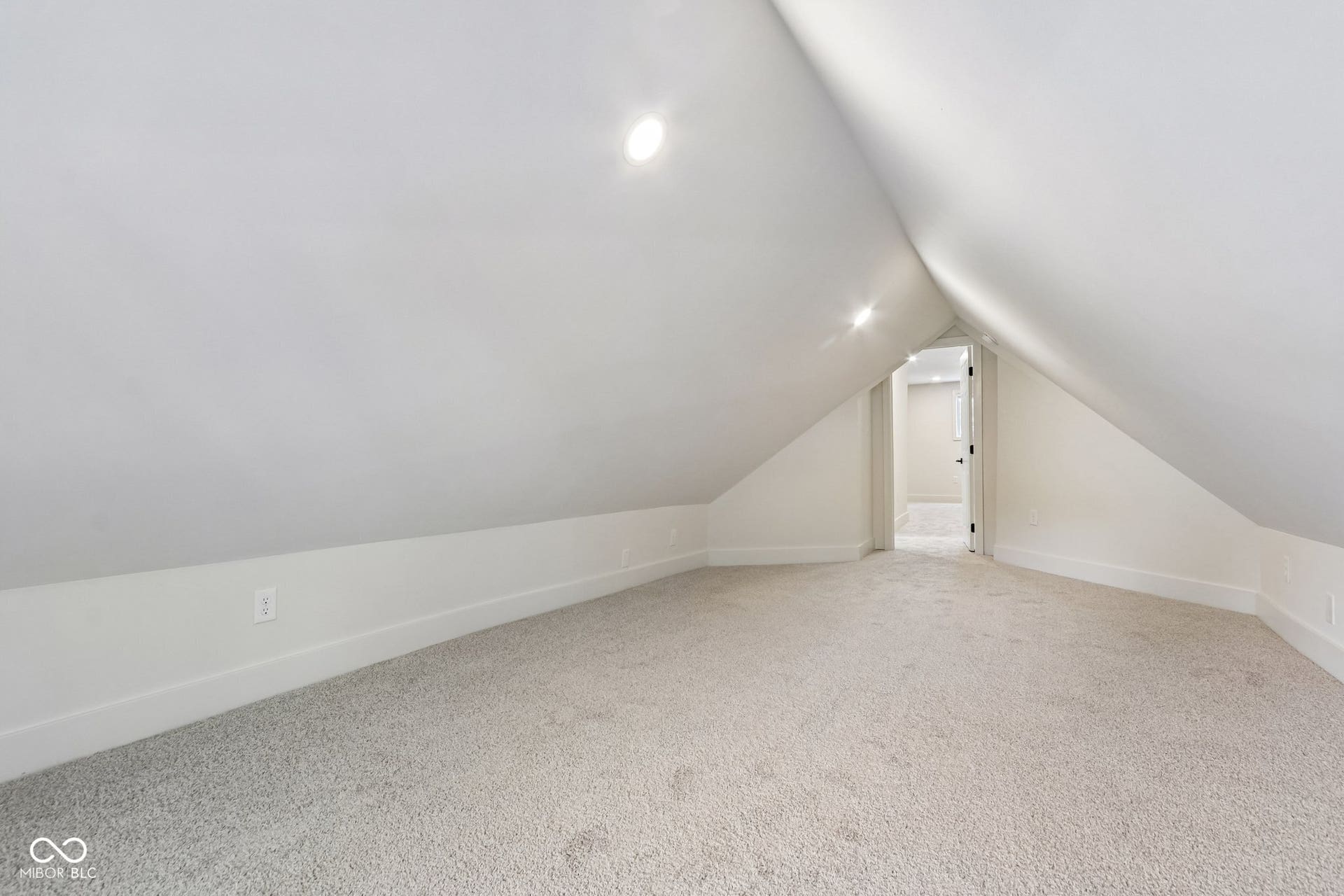 Carpeted attic space with recessed lighting and sloped ceilings