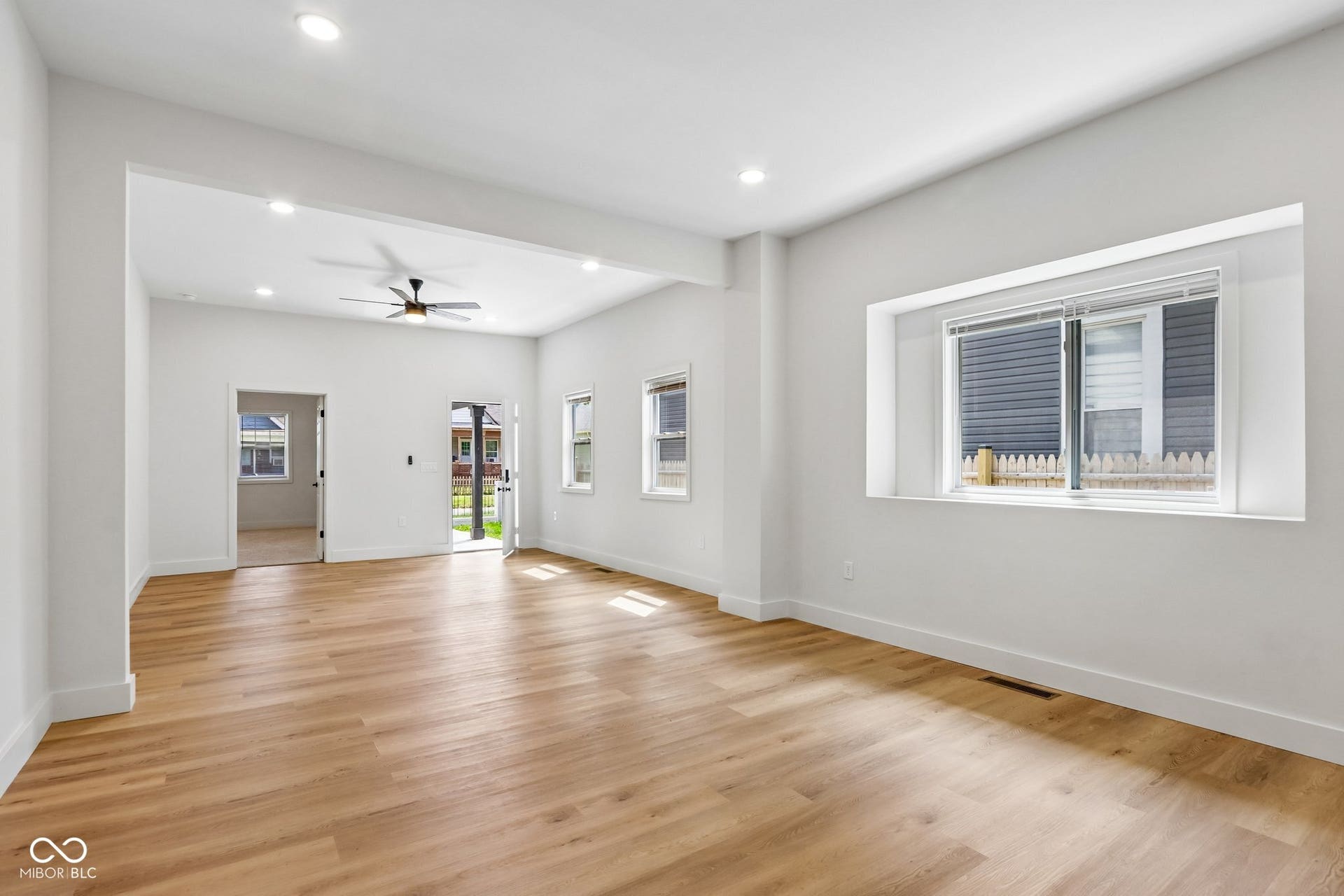 Spacious living area featuring wood-finish flooring, recessed lighting, and a ceiling fan