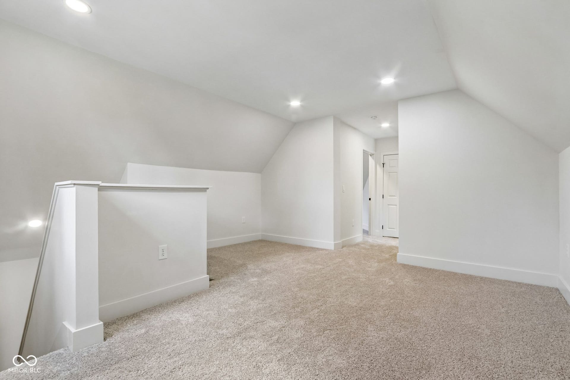 Carpeted loft area with recessed lighting, angled ceilings, and white trim