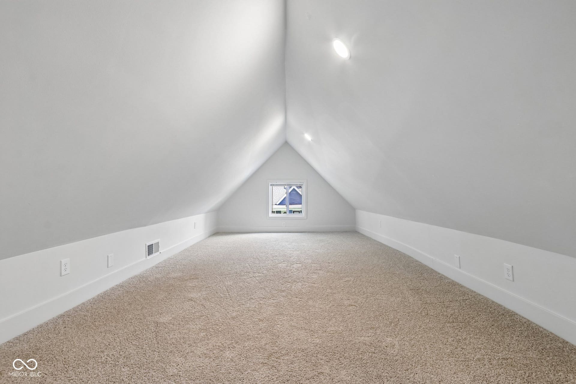 Carpeted attic space with sloped ceilings, recessed lighting, and a window