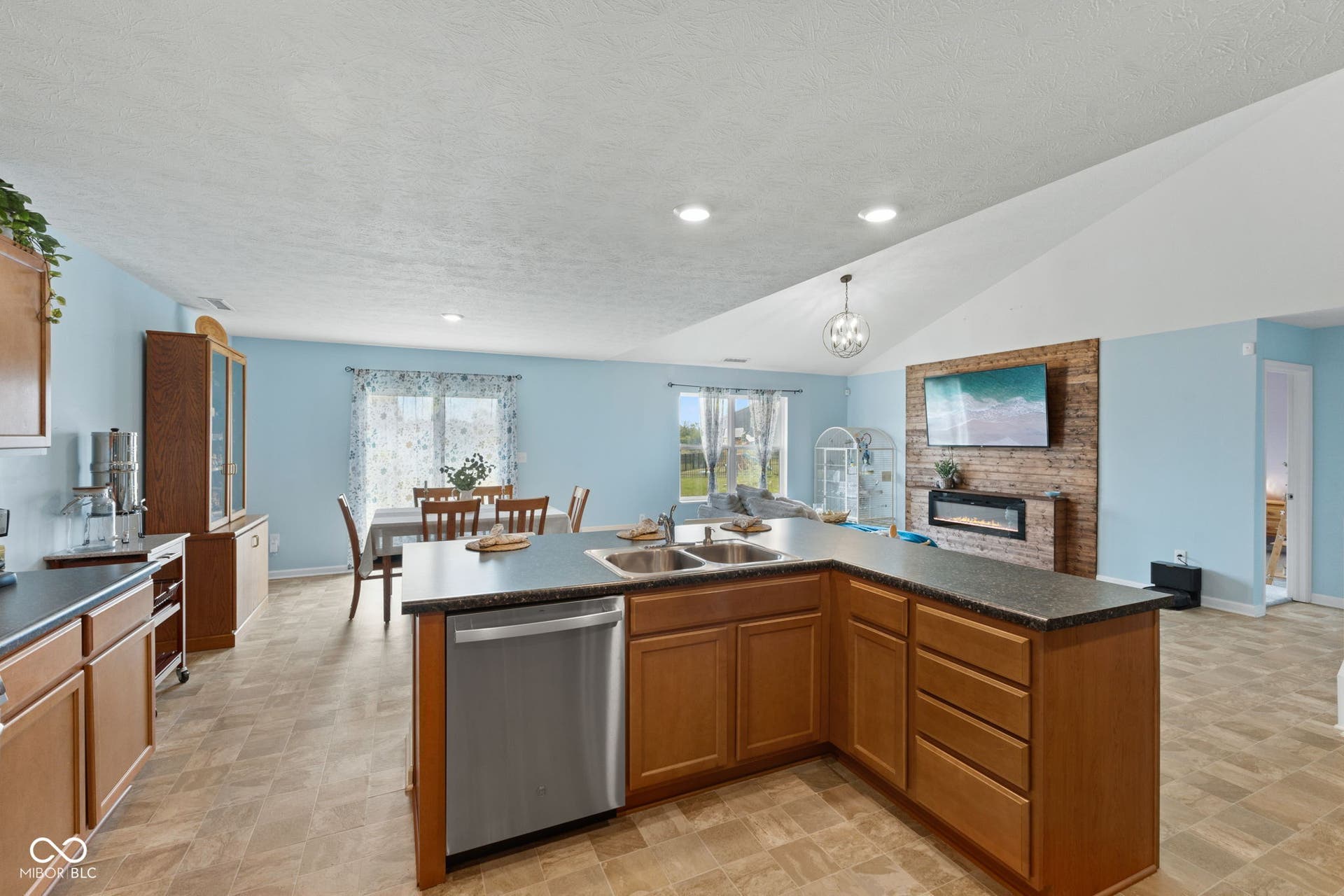 4643 Darla Court, Indianapolis, IN 46239 Open-concept living area with vaulted ceilings, a brick-finish accent wall, and electric fireplace