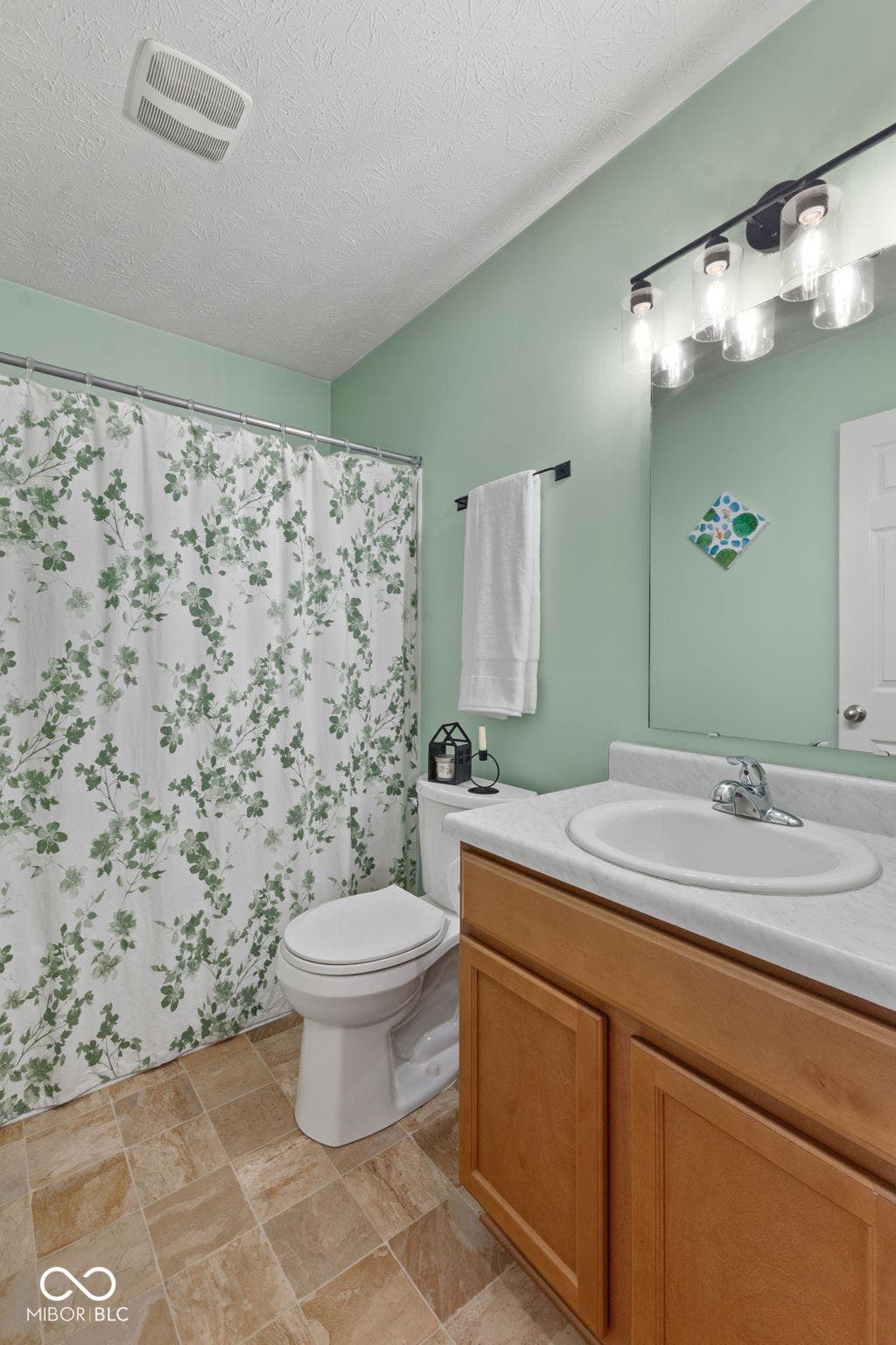 4643 Darla Court, Indianapolis, IN 46239 Vinyl flooring, single basin vanity, integrated sink, wood cabinetry, and a modern light fixture