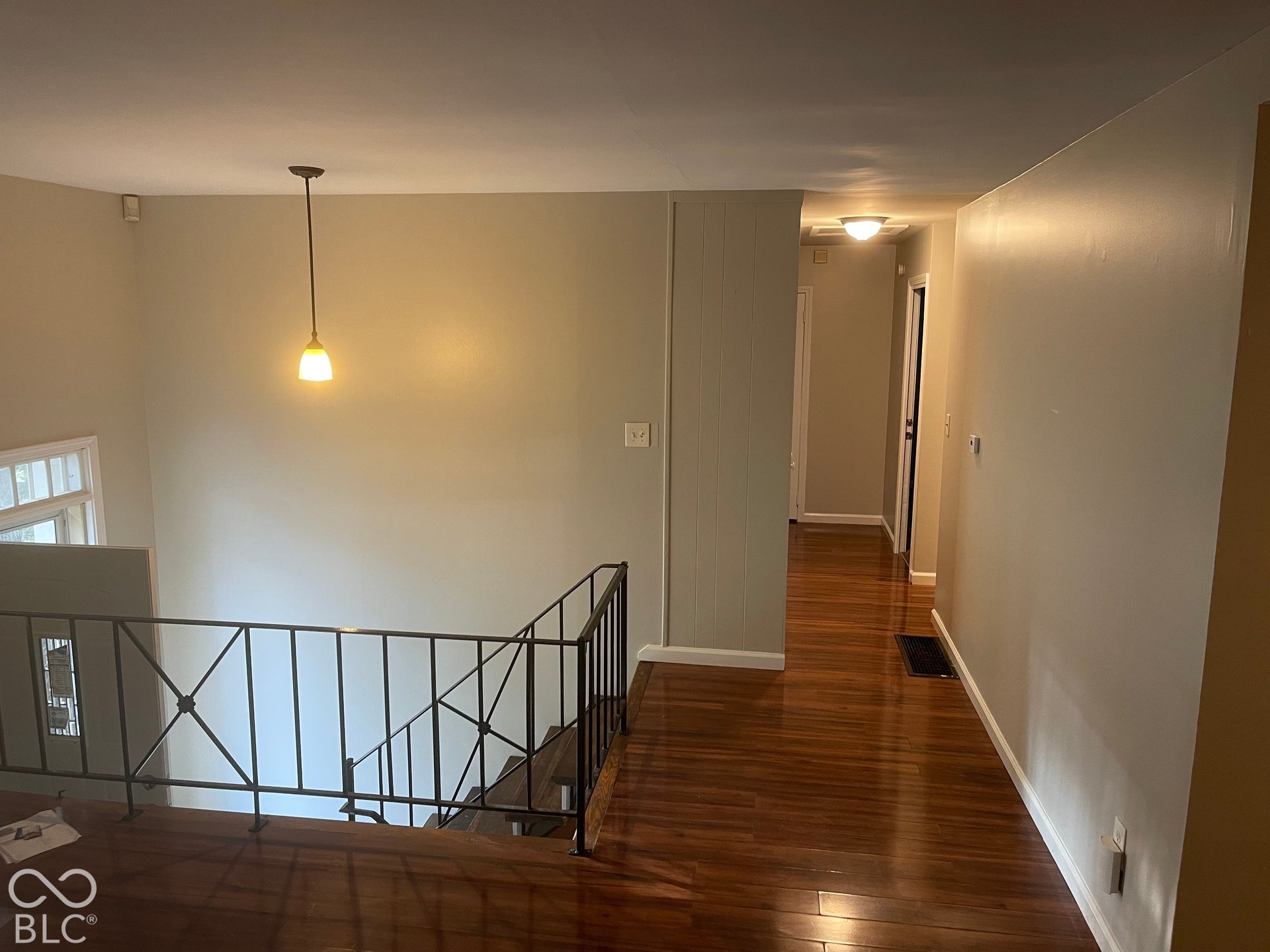 3913 Eisenhower Drive, Indianapolis, IN 46254 Hardwood flooring throughout, contemporary pendant lighting, recessed hallway lighting, and wrought iron railing
