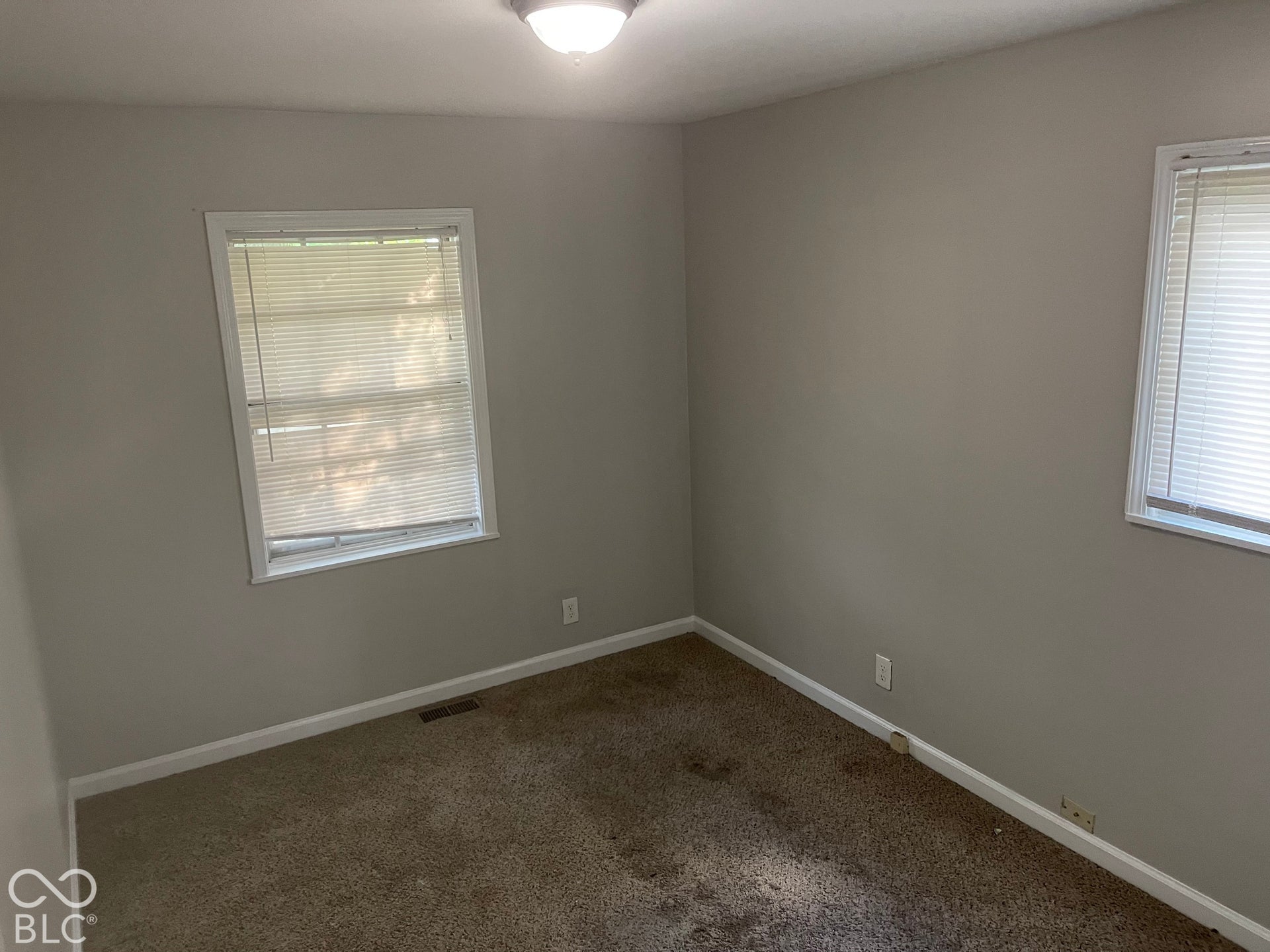 3913 Eisenhower Drive, Indianapolis, IN 46254 Room featuring two windows with horizontal blinds and neutral-toned walls