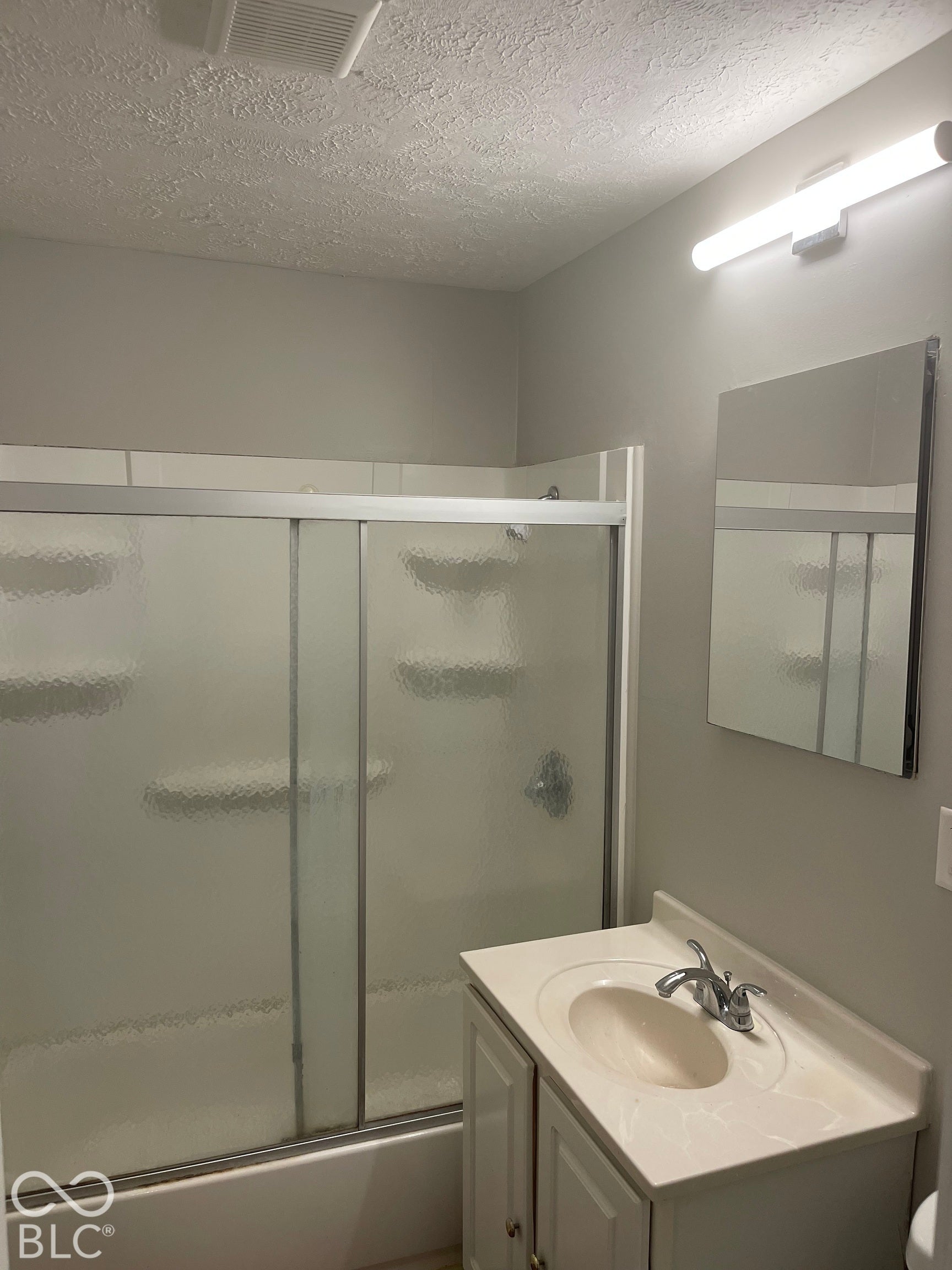 3913 Eisenhower Drive, Indianapolis, IN 46254 Bathroom featuring a vanity with an integrated sink, chrome faucet, and a wall-mounted mirror