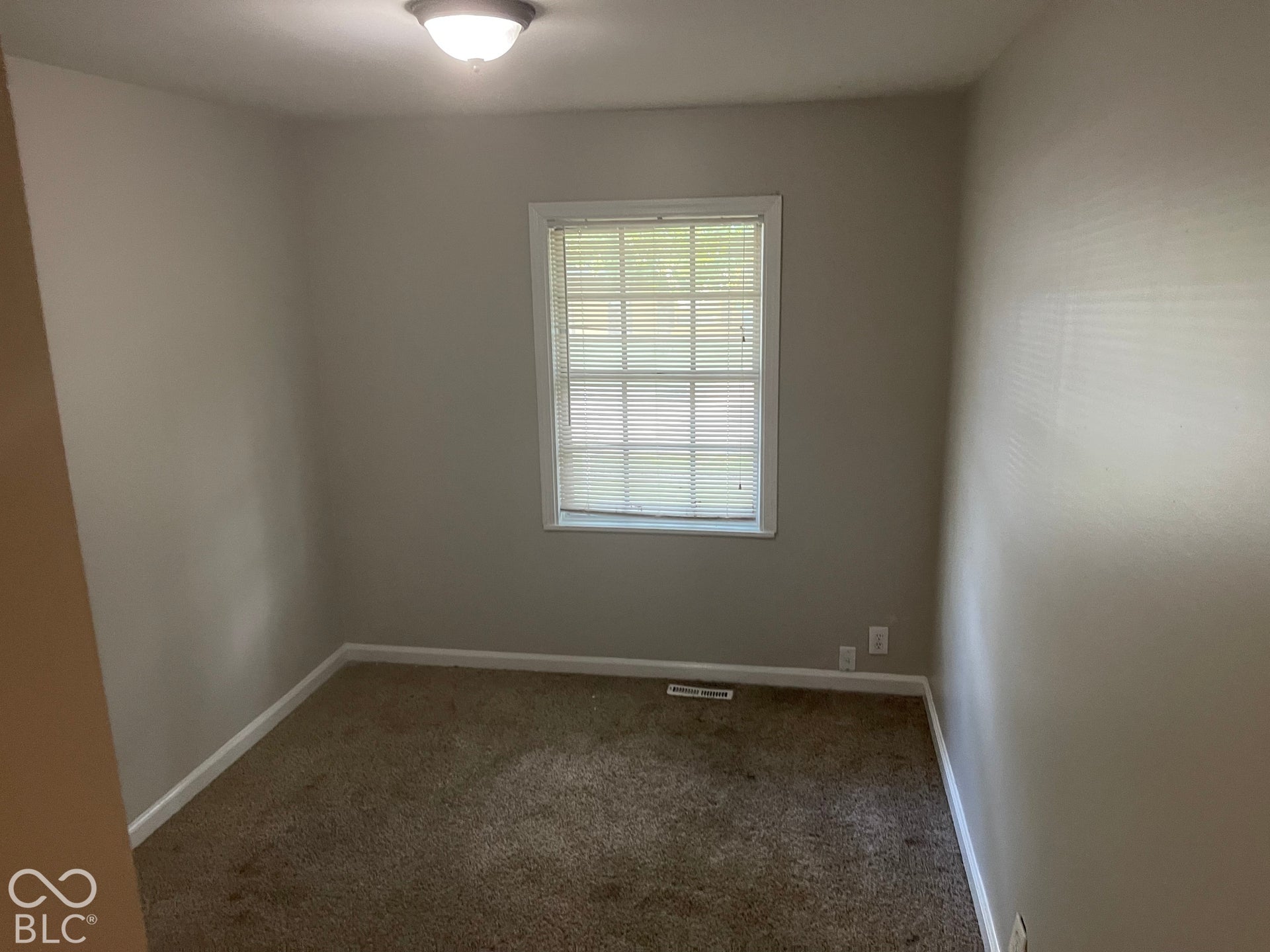3913 Eisenhower Drive, Indianapolis, IN 46254 Neutral wall paint, carpeted flooring, and a single window with blinds