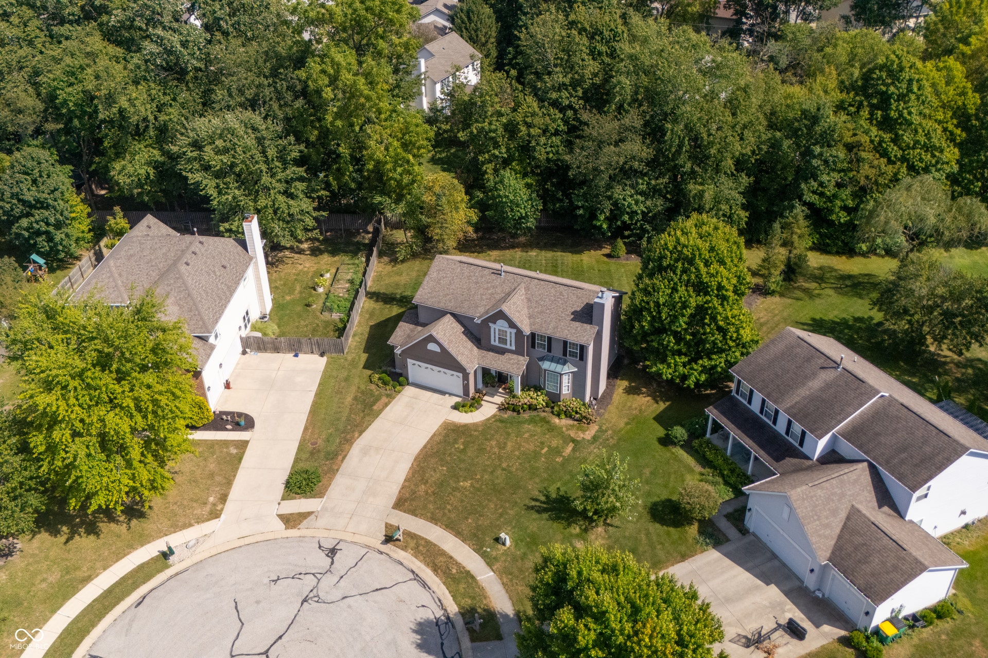 Two-story property featuring a front-facing garage, bay window, and gabled roofline, situated on a cul-de-sac