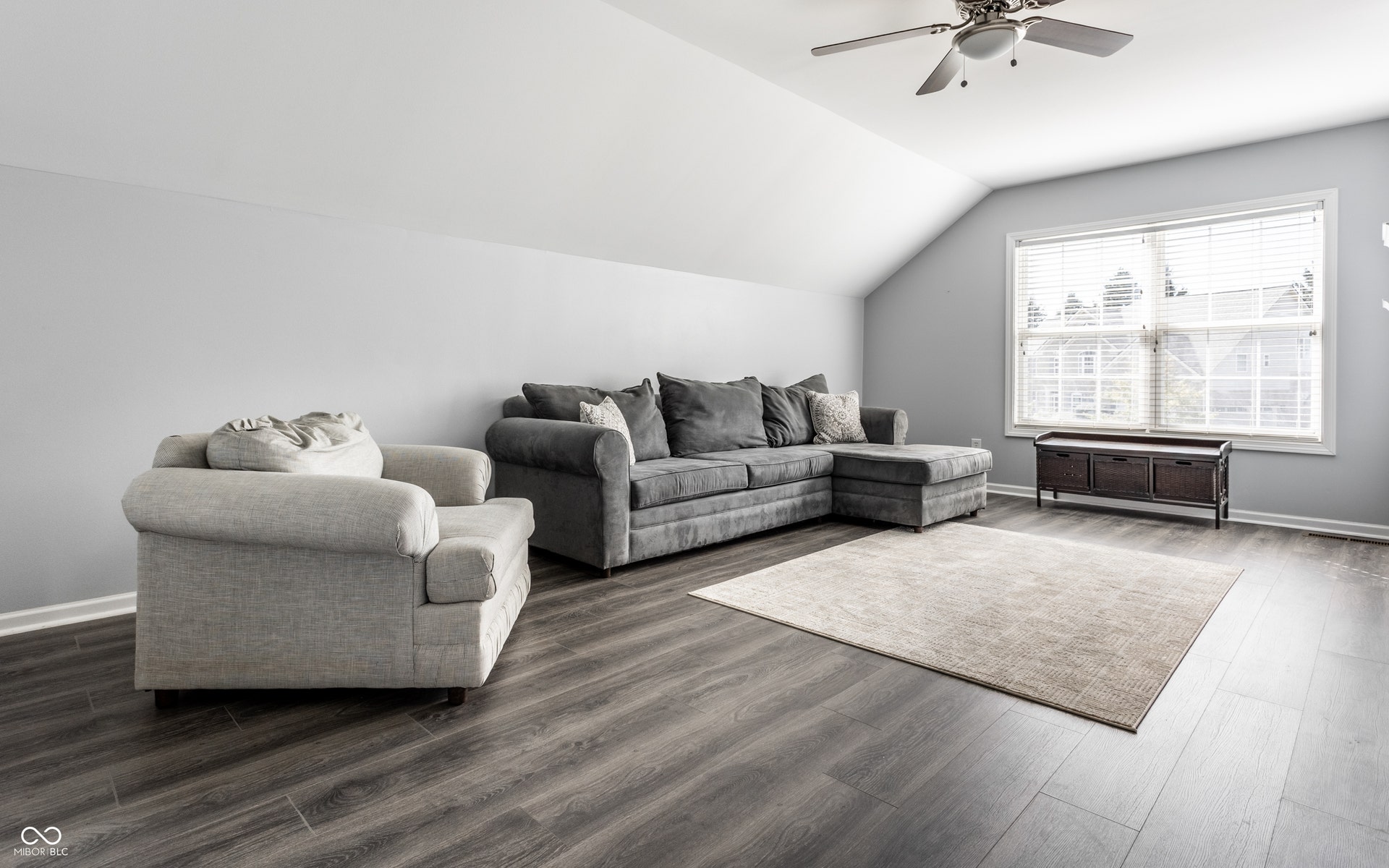 Vaulted ceiling with a ceiling fan, luxury vinyl plank flooring