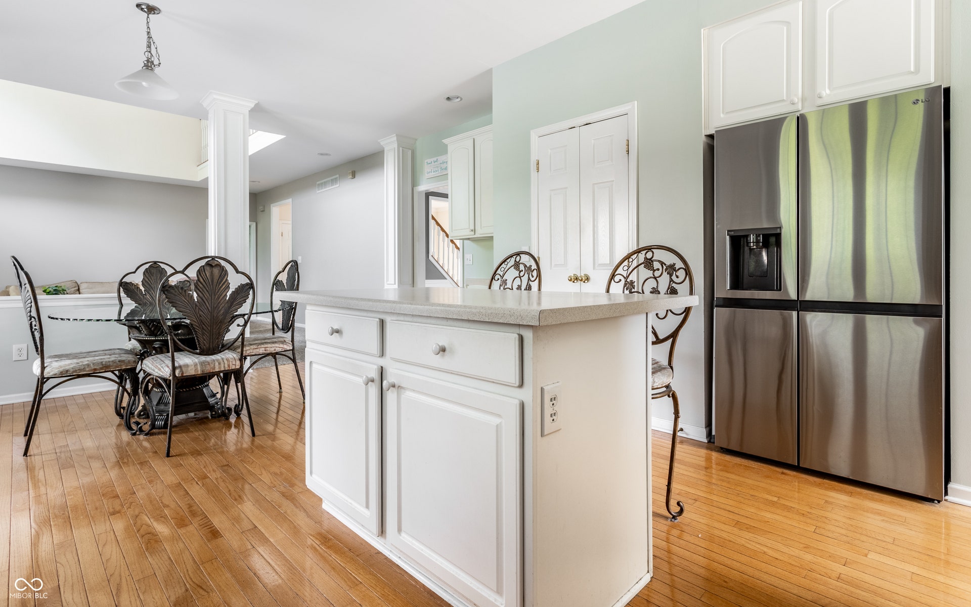 Kitchen island with white cabinetry and light-toned countertop