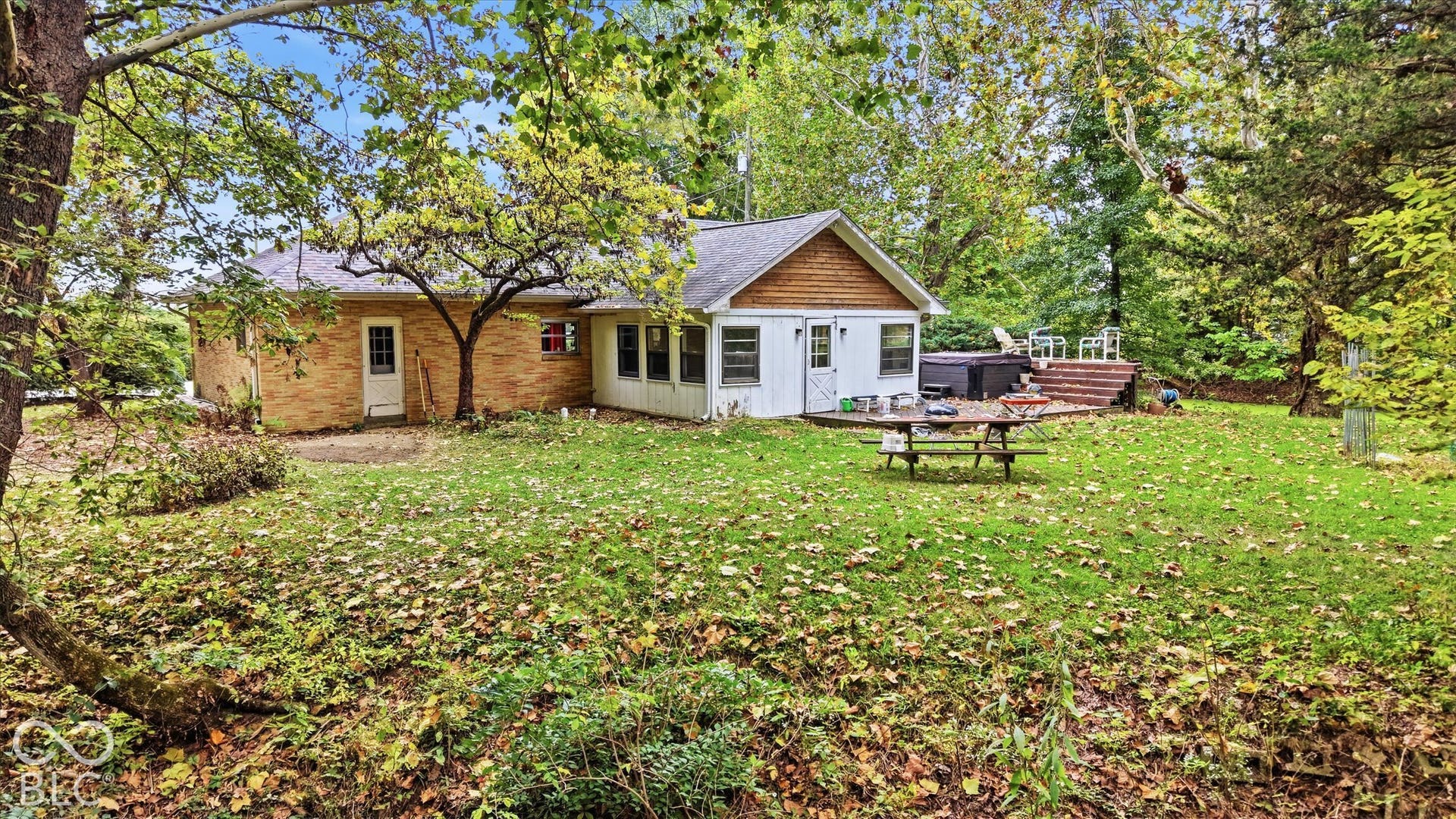 Brick exterior with white trim, sunroom, and wood deck
